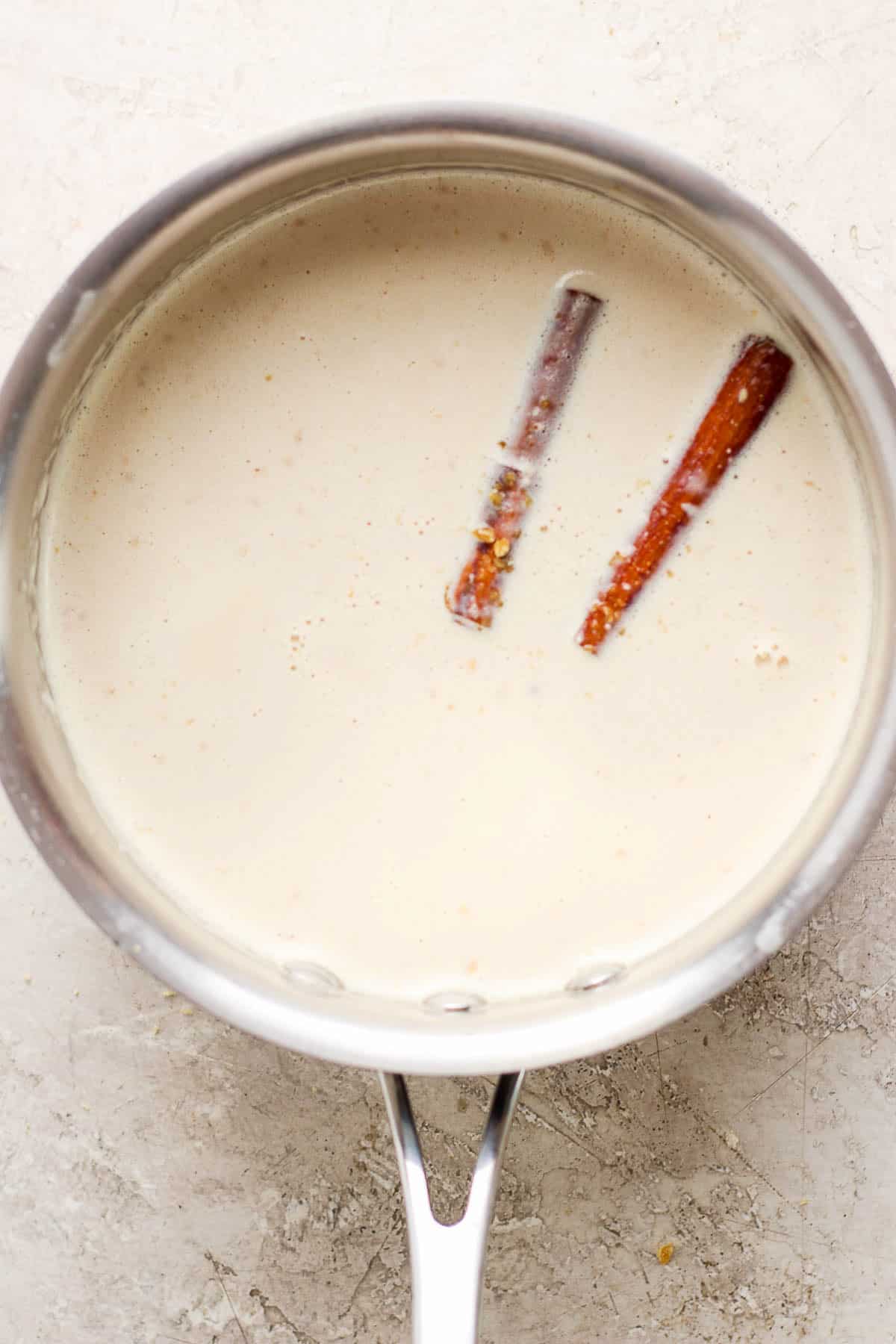 Warmed milk mixture in a pot for atole de galletas.