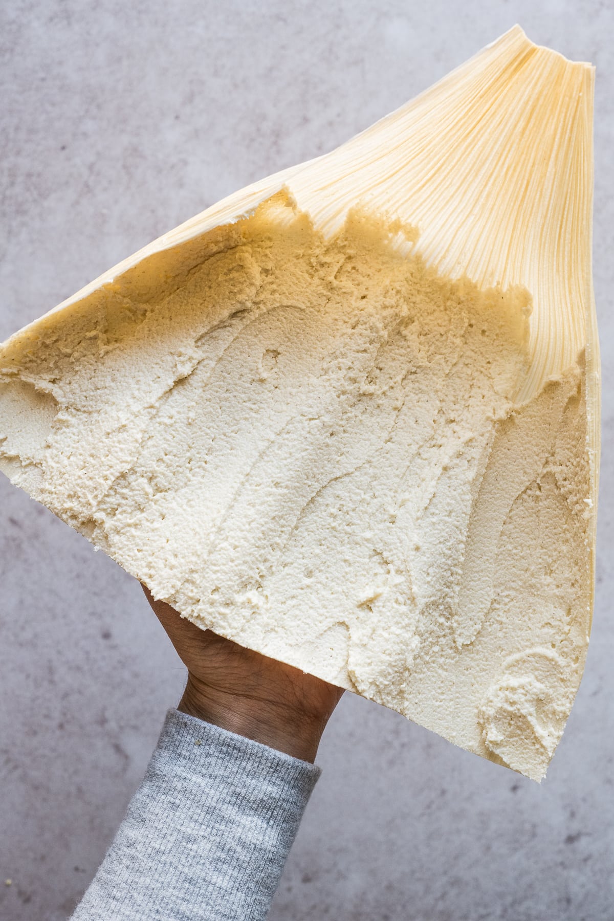 A corn husk with masa smeared on it.