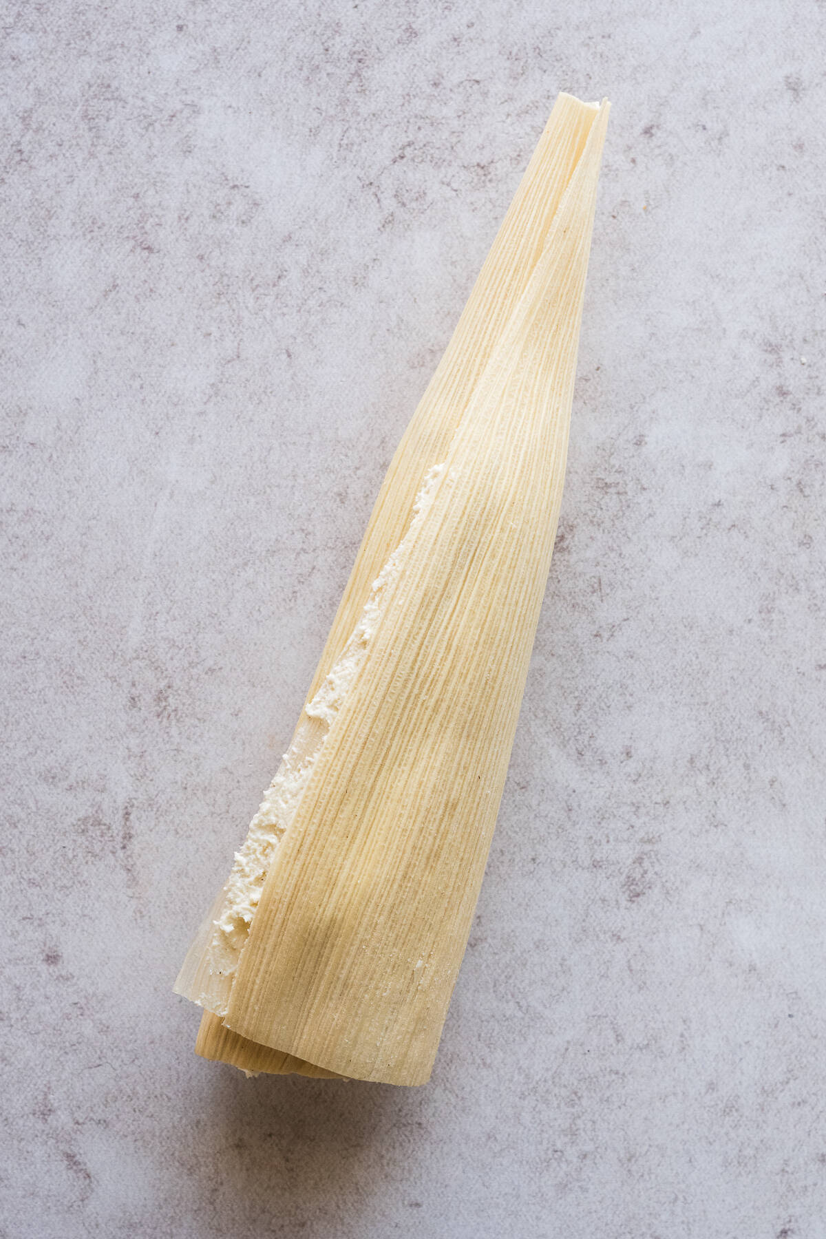 Step by step photos of how to fold and assemble tamales.