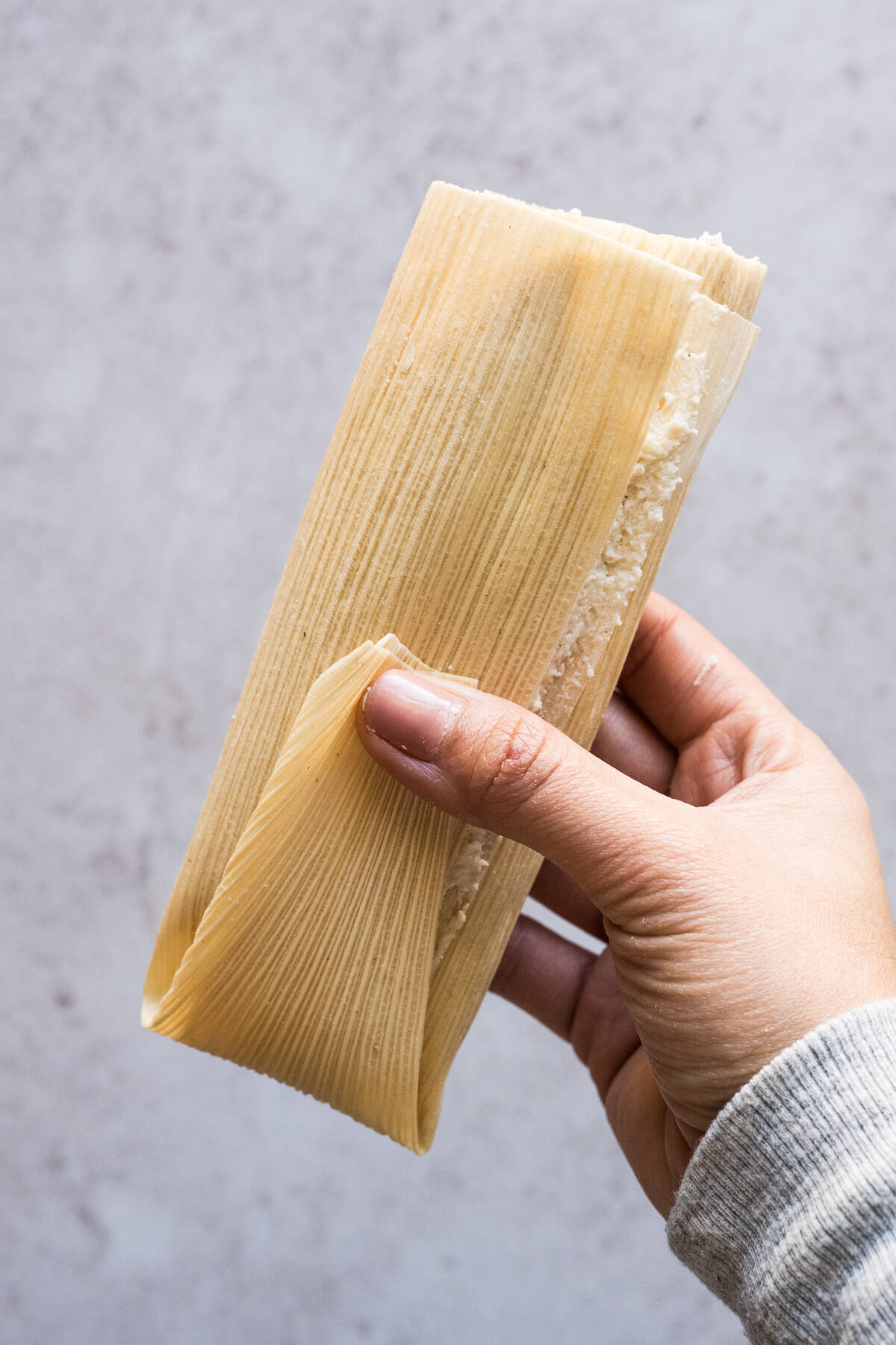 A folded tamale ready to be steamed and cooked.