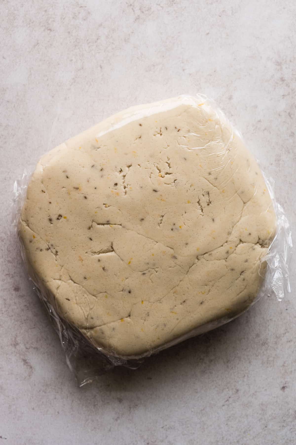 Biscochito dough wrapped in plastic wrap.