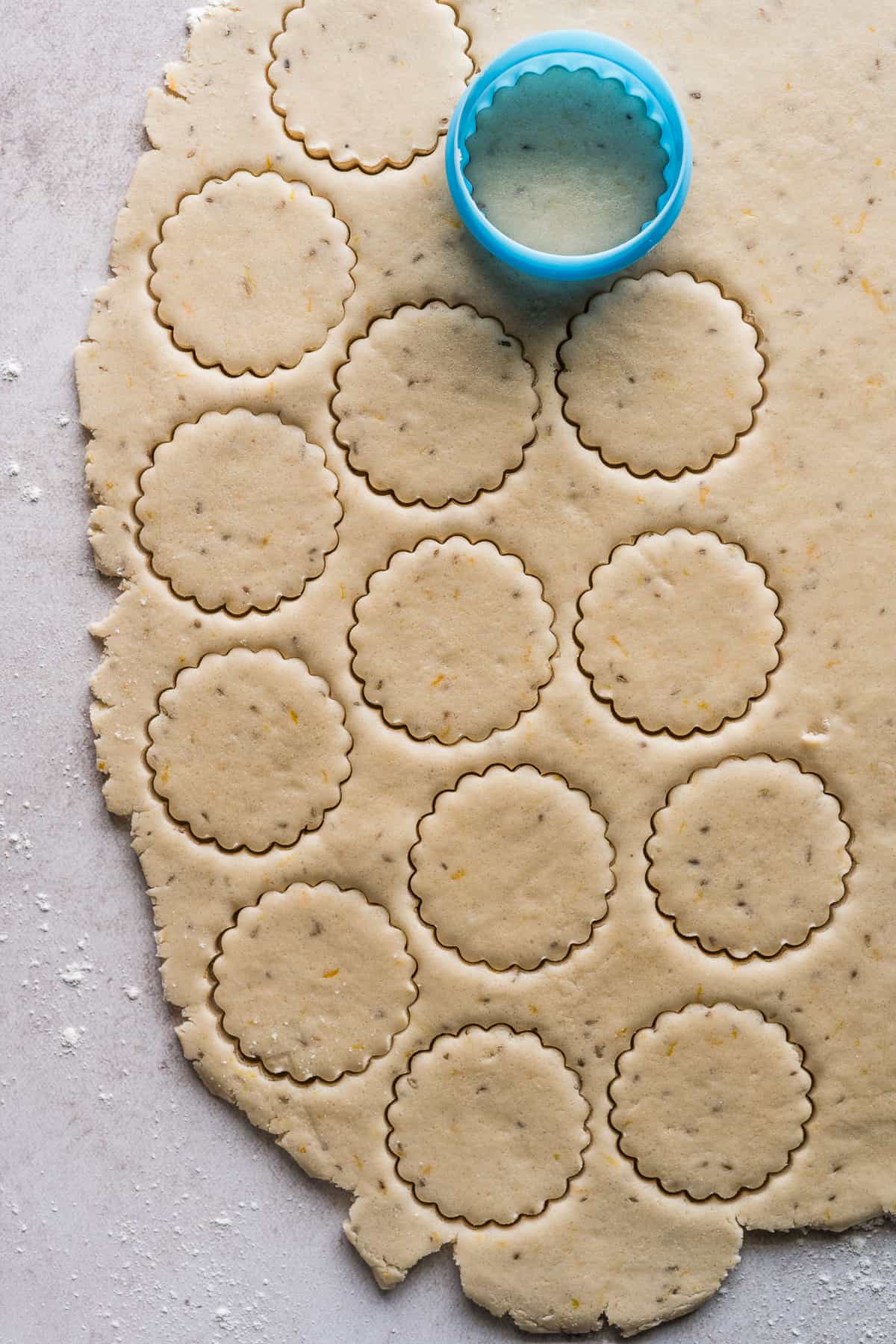 Biscochitos being stamped out with a cookie cutter.
