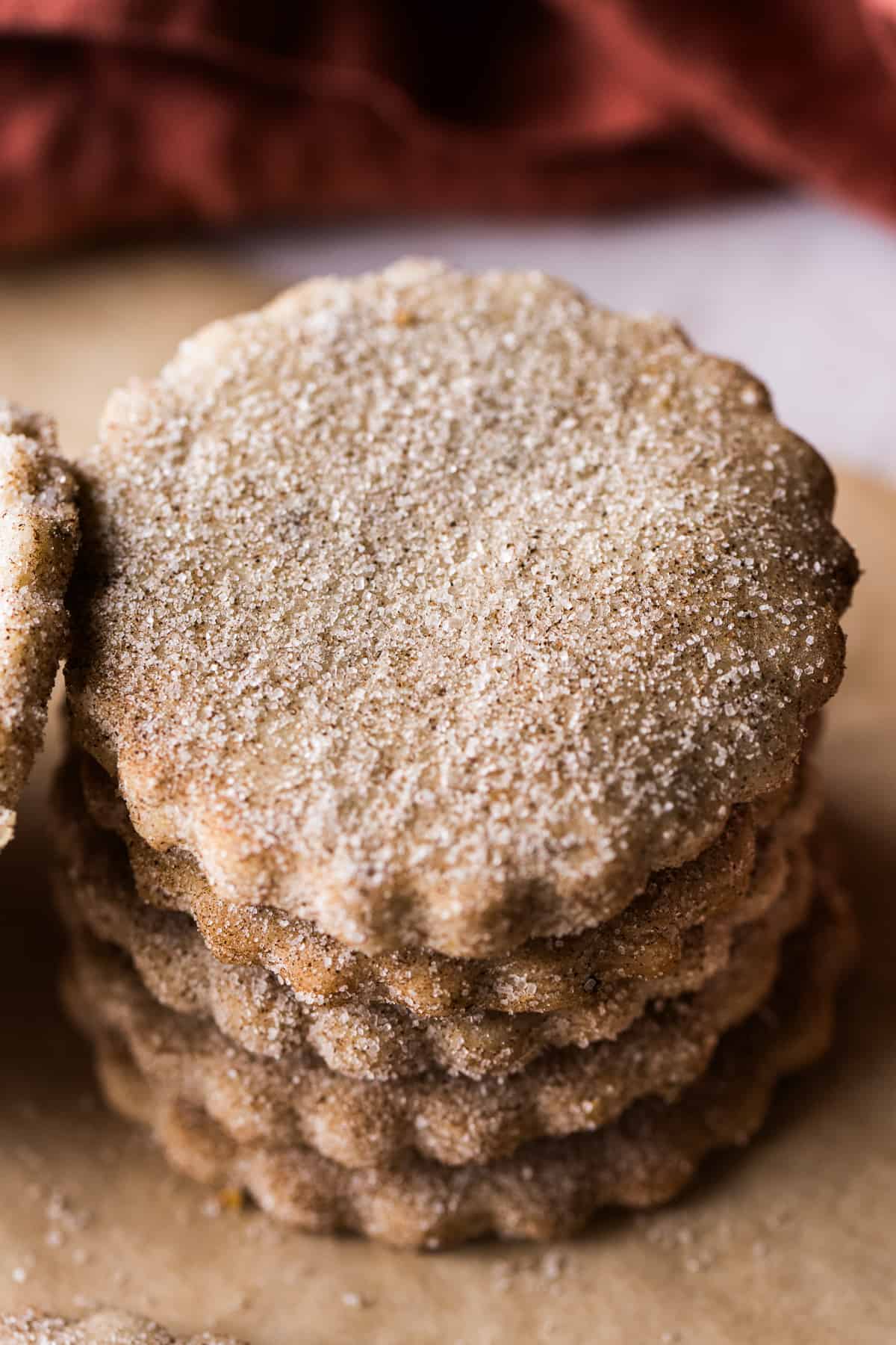 Biscochitos stacked on top of one another coated in cinnamon sugar.