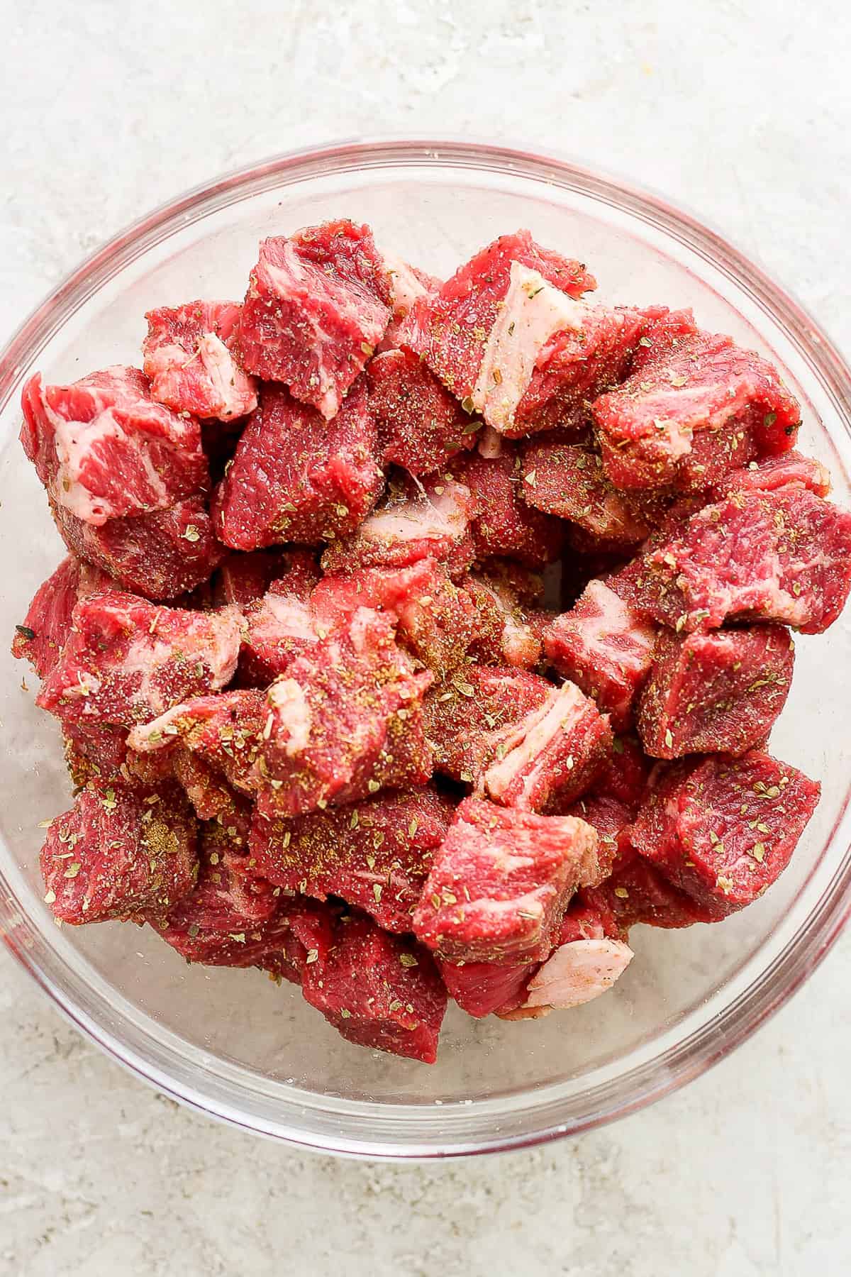 Seasoned beef chuck roast in a large bowl.