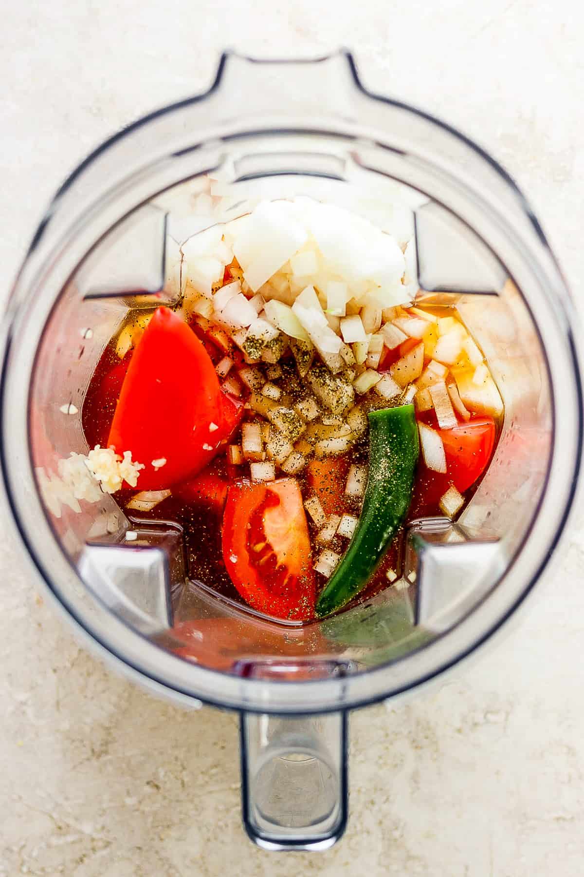 Broth, onion, tomatoes, and serrano in a large blender.