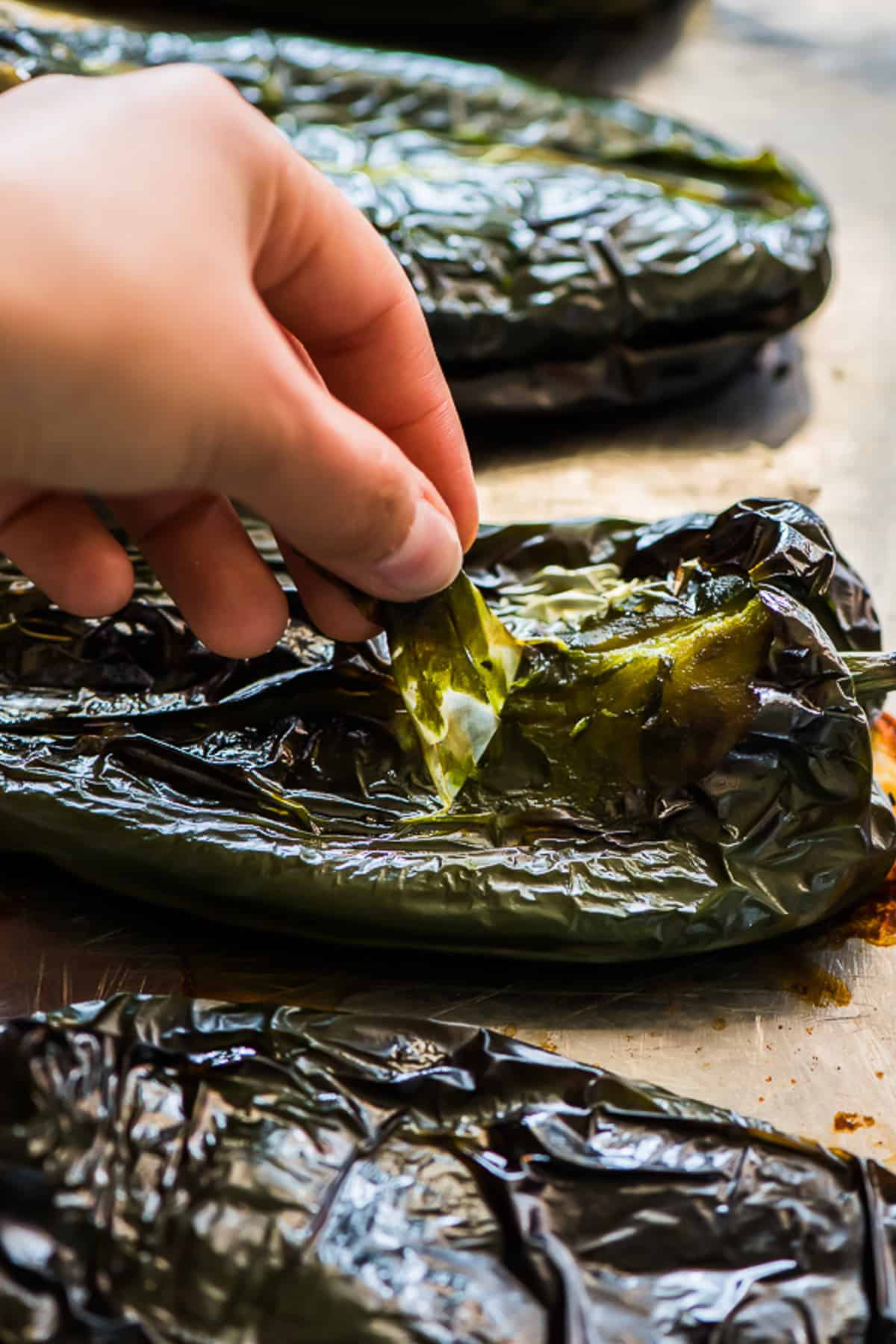 Roasted poblano peppers being peeled.