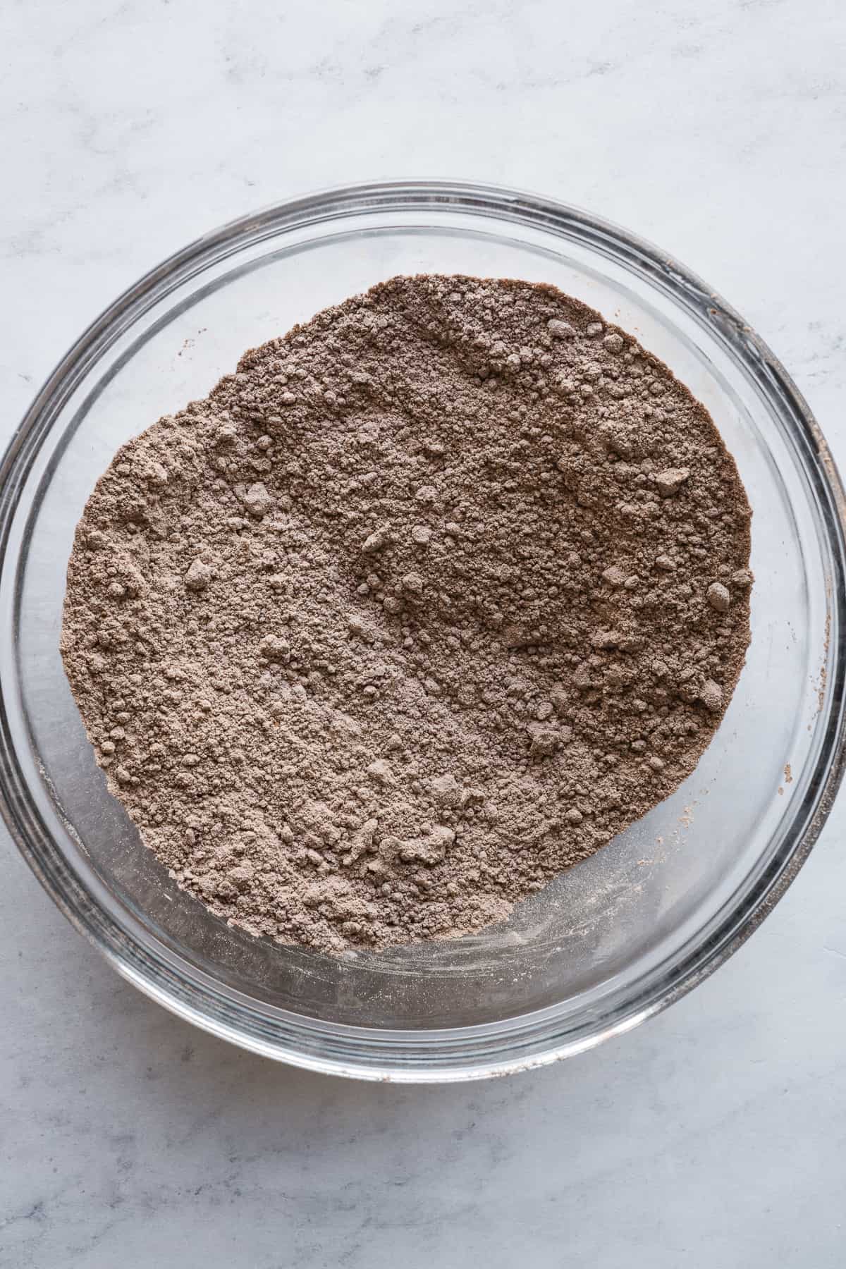 The dry ingredients for a chocolate cake in a large mixing bowl.