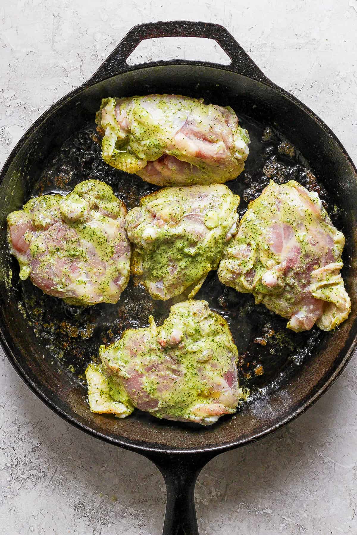 Cilantro lime chicken being seared in a skillet with the skin side down.
