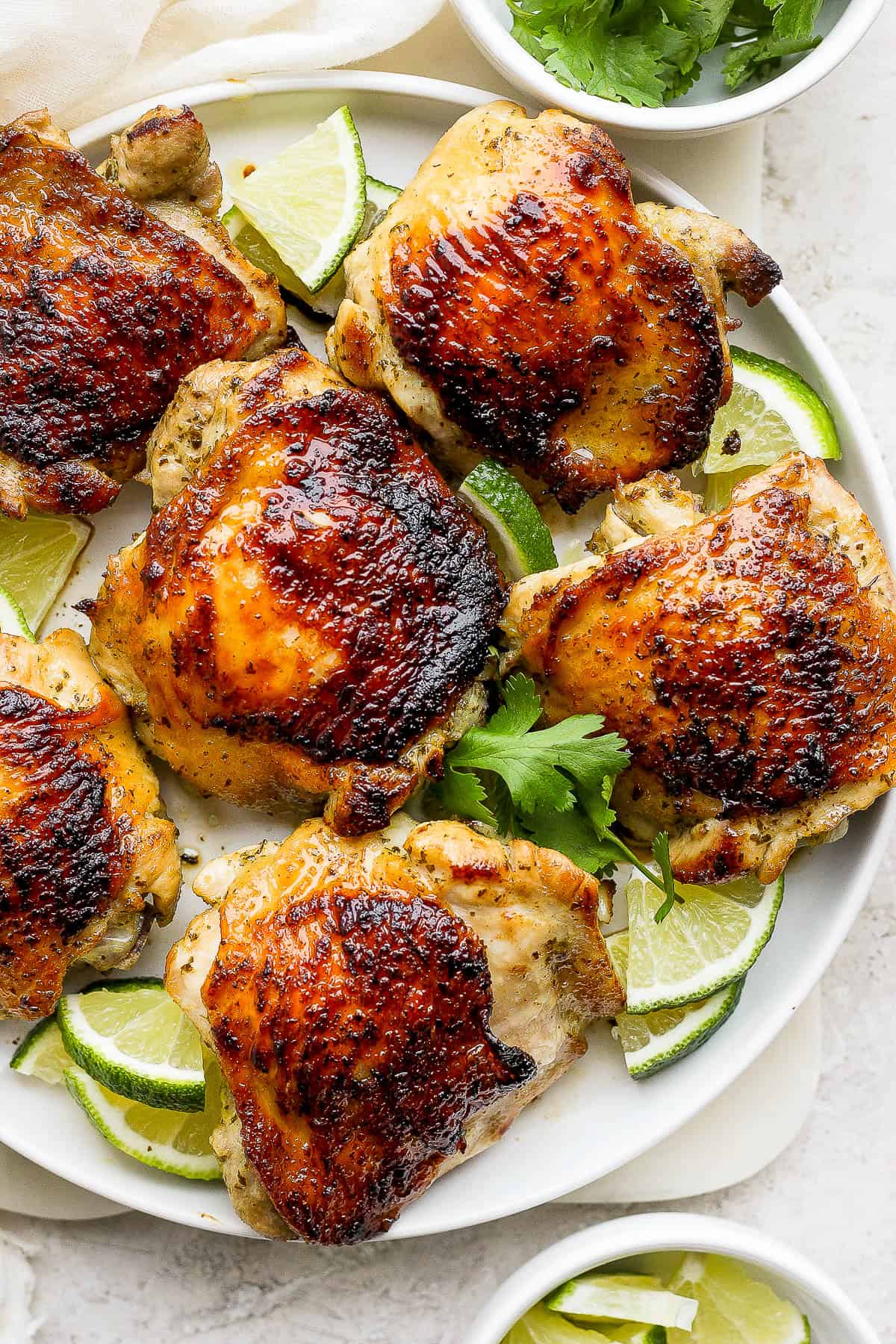 Cilantro lime chicken thighs on a plate with crispy and golden brown skin.