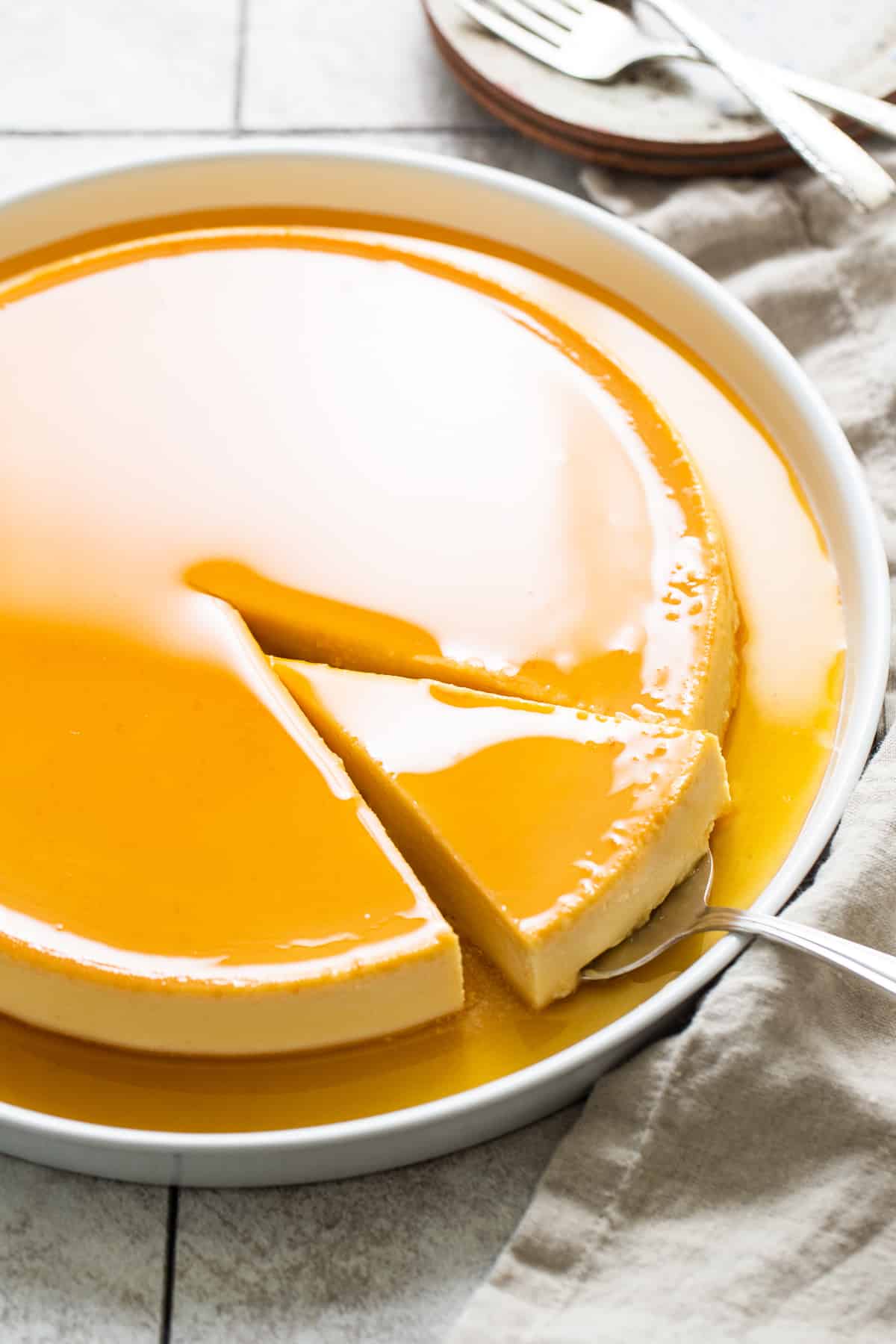 A slice of flan de queso on a serving spoon.