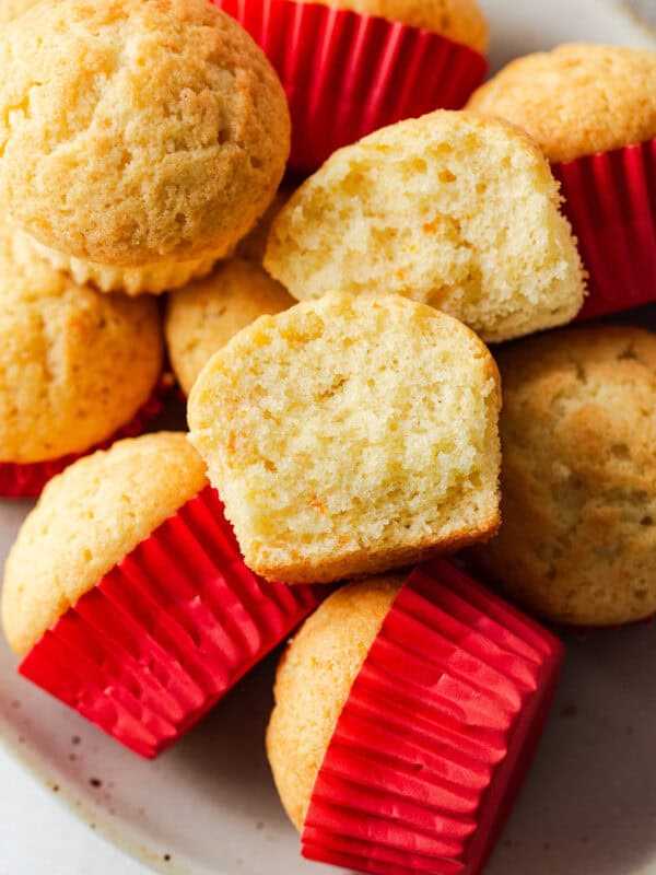 Mantecada muffins on a table with a red muffin cupcake liner.
