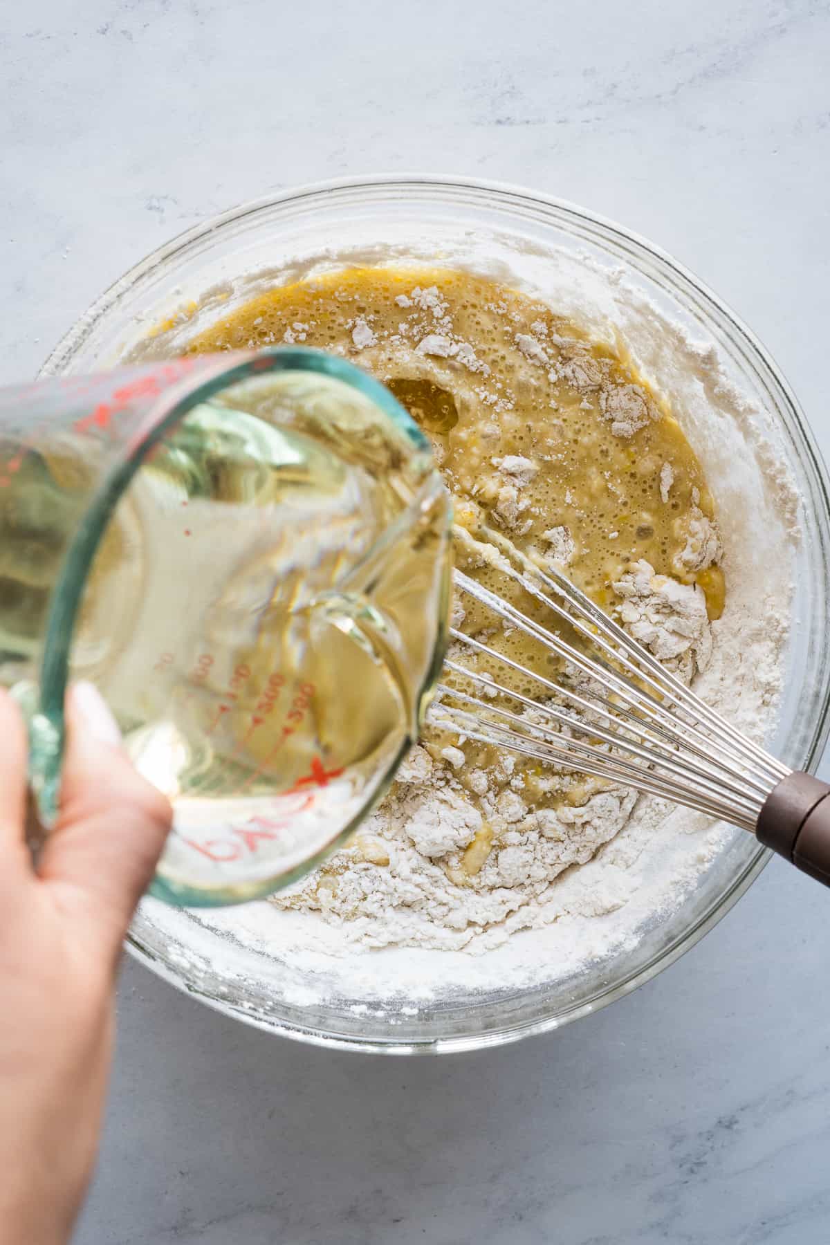 Vegetable oil being poured into the batter of mantecadas.