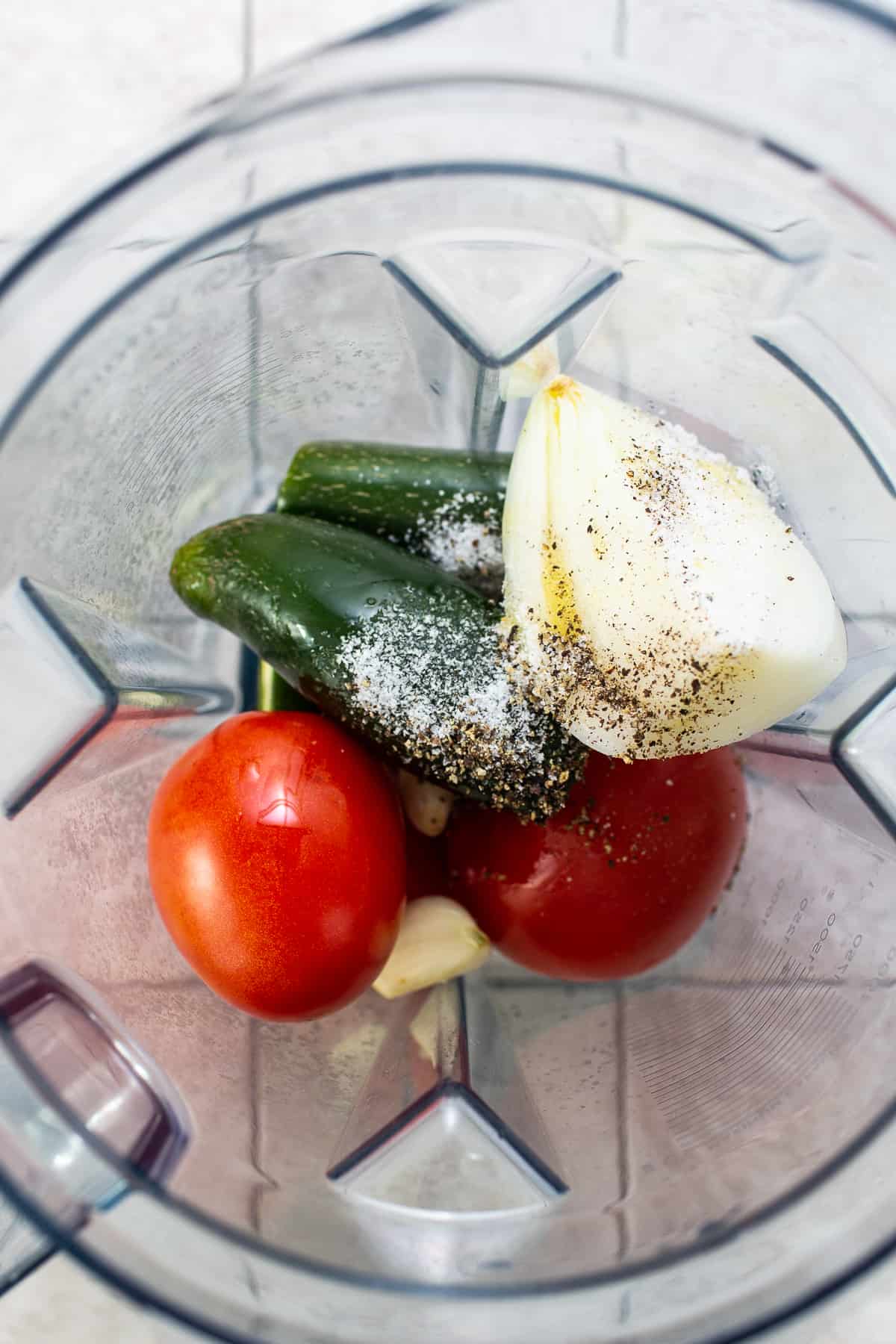 Jalapeños, tomatoes, onion, garlic, salt, and black pepper in a blender.