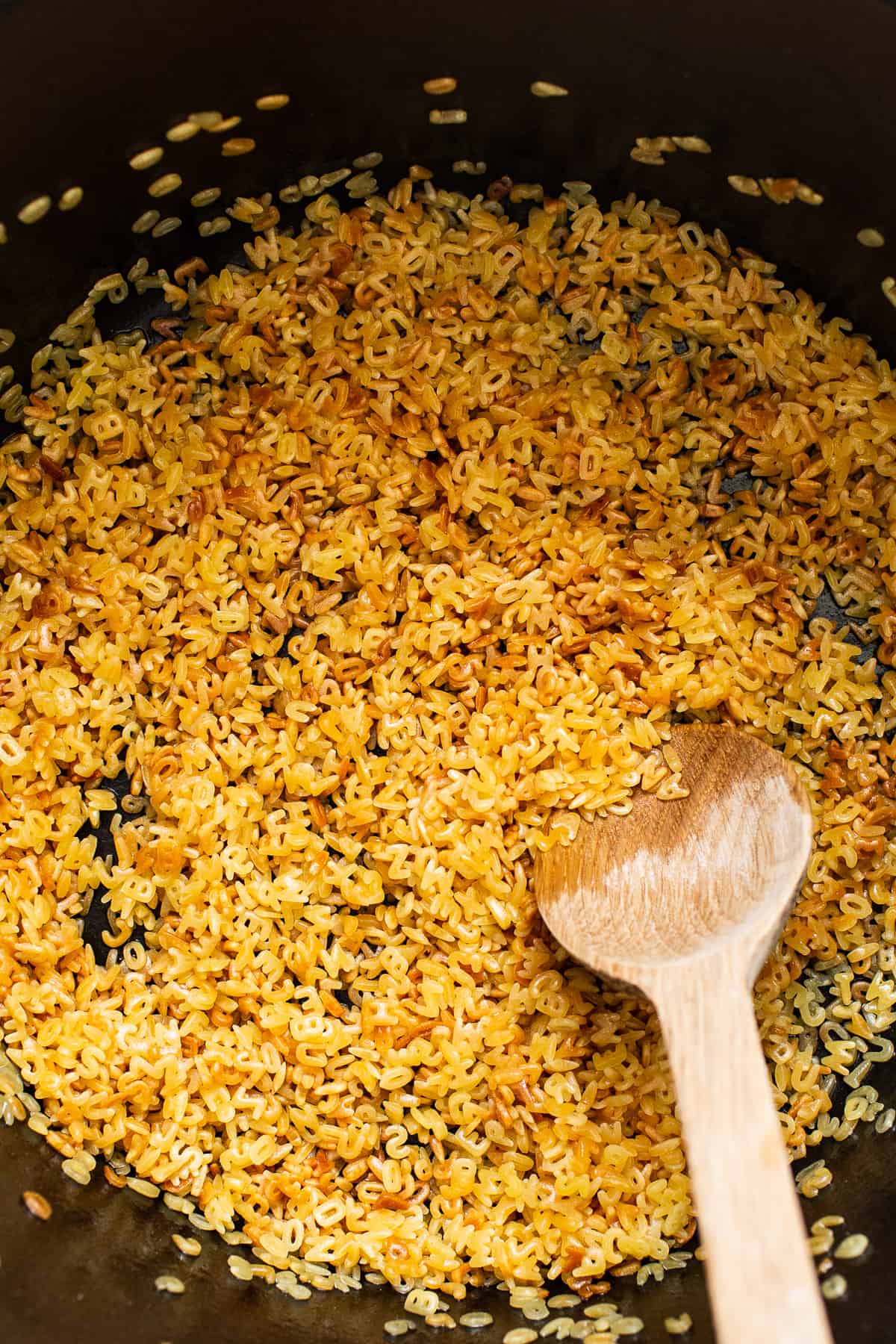 Alphabet pasta being cooked in oil for sopa de letras.