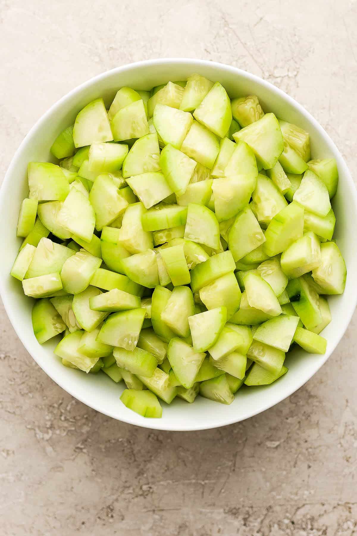 Peeled and chopped cucumbers in a large bowl.