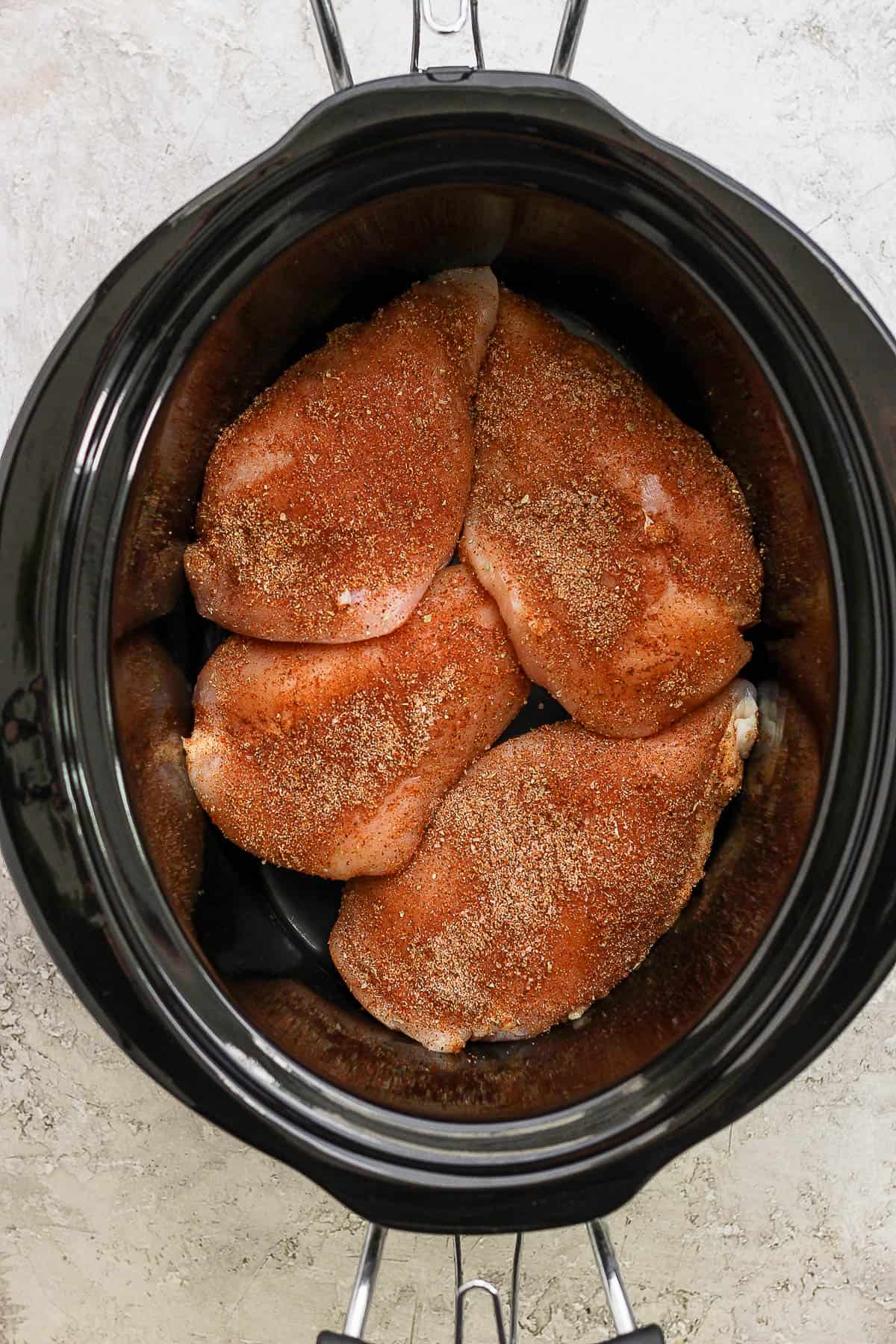 Seasoned chicken breast in a slow cooker.