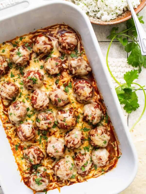 Enchilada meatballs in a baking dish garnished with cilantro.