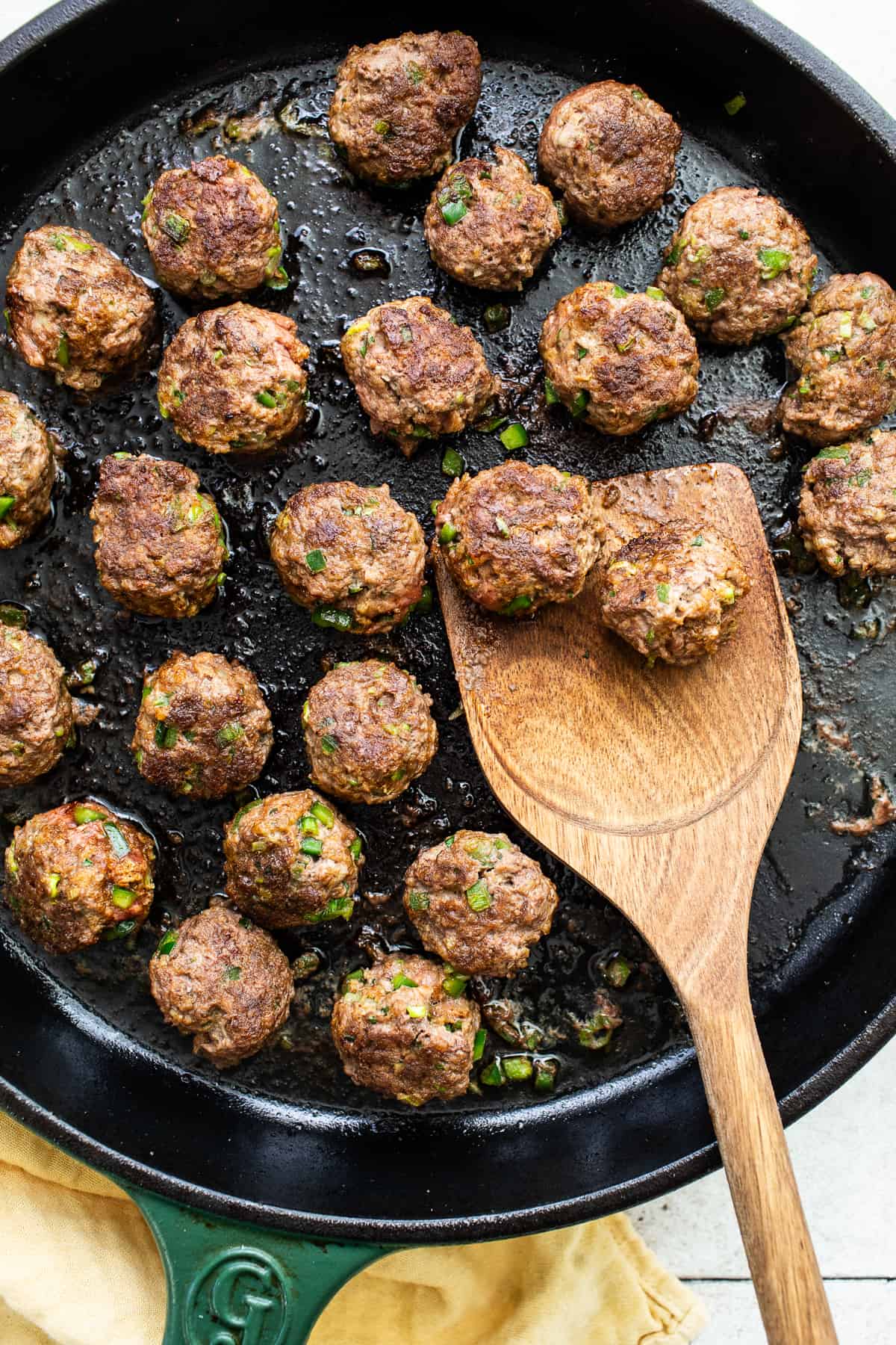 Meatballs seared in a cast iron skillet.
