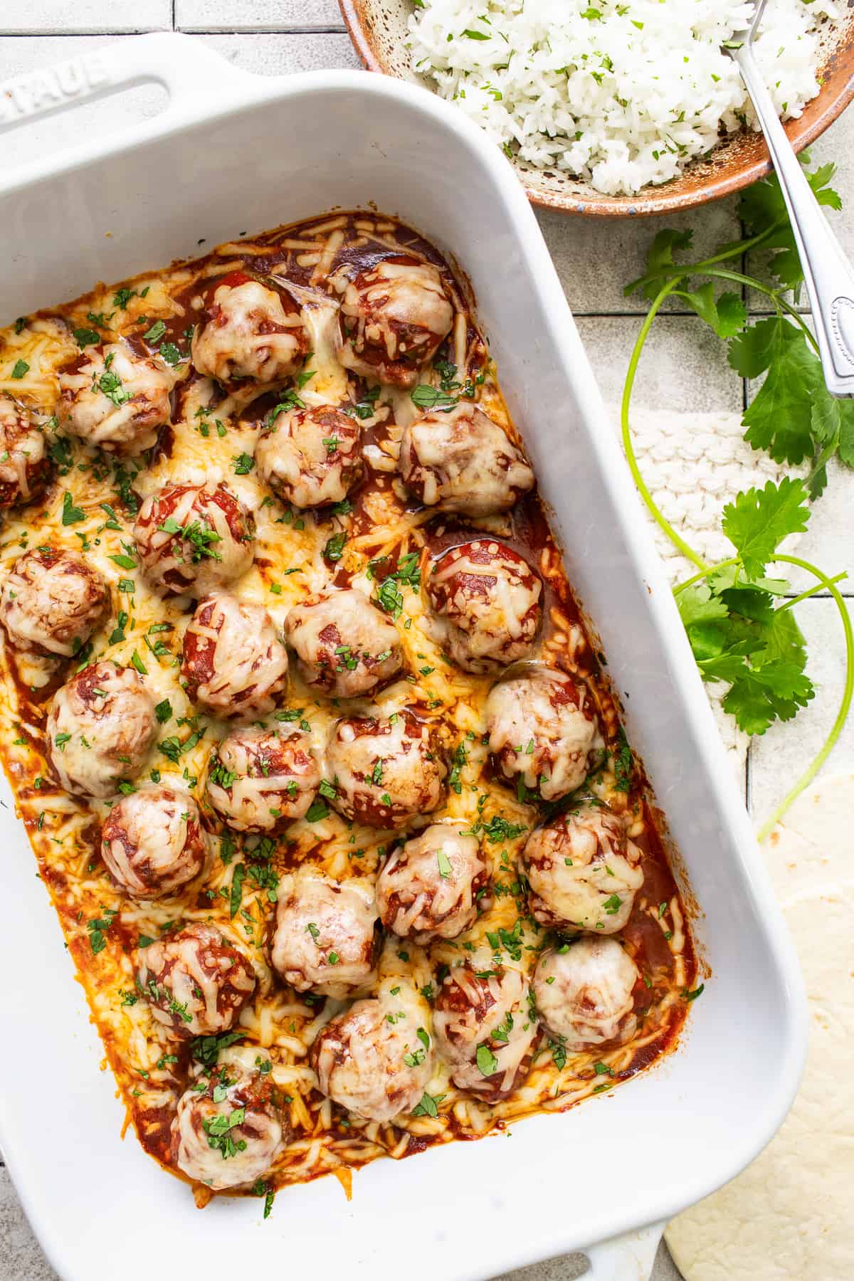 Enchilada meatballs in a  baking dish garnished with cilantro.