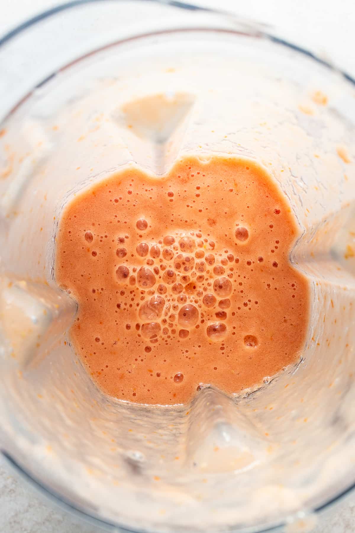 A blended tomato and onion mixture in a blender for Mexican vegetable soup.