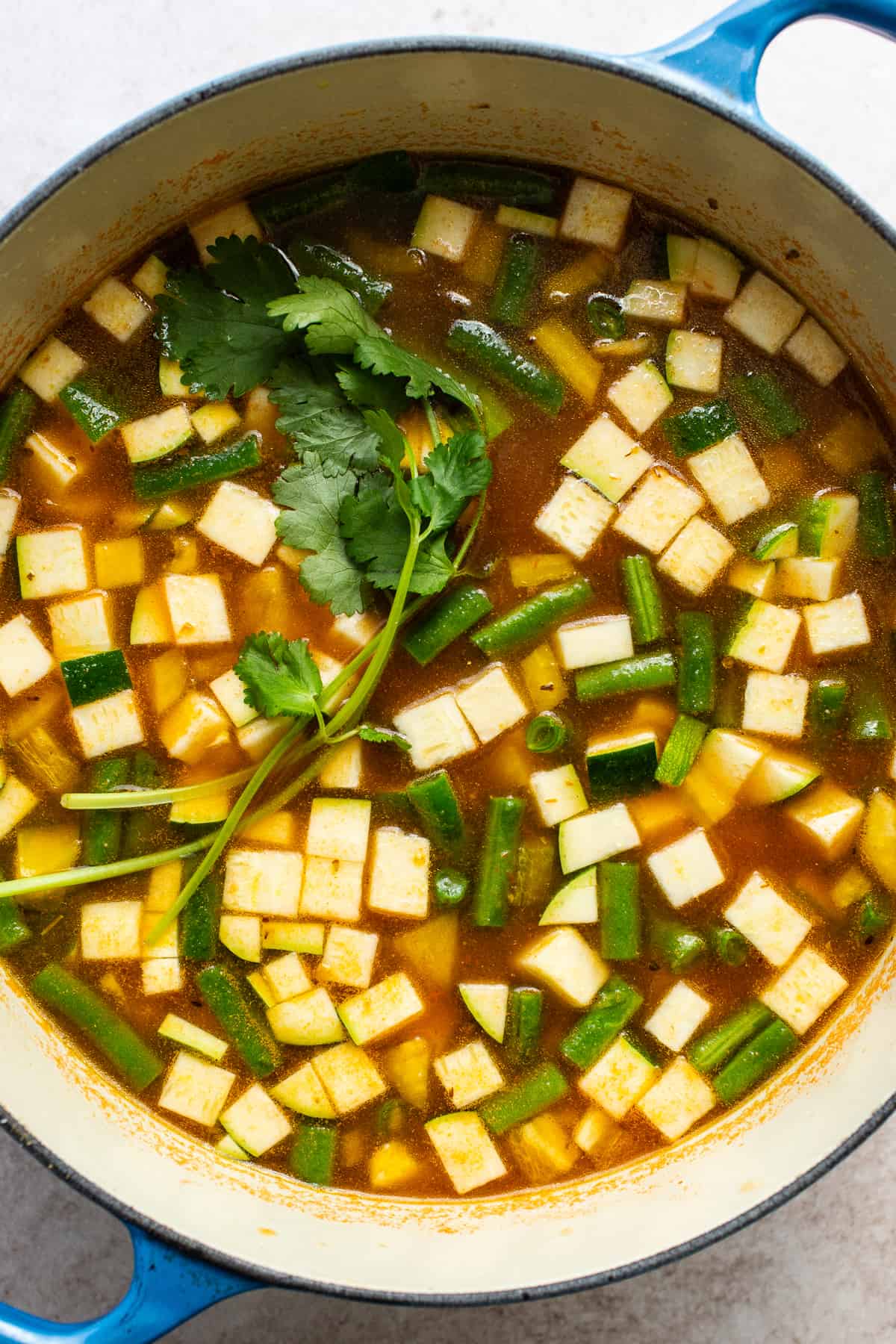 Diced vegetables in a pot with broth.