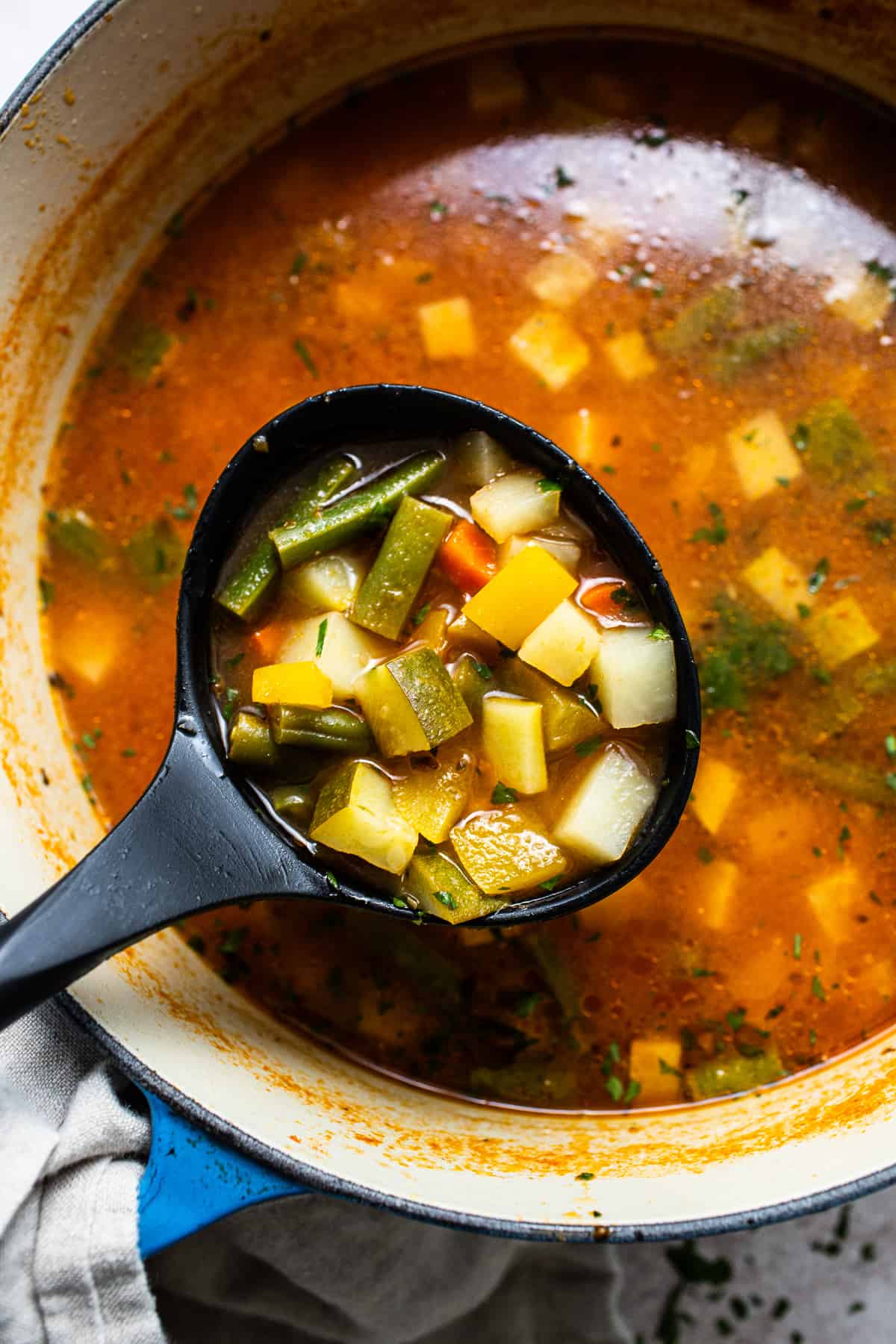 Mexican vegetable soup in a ladle.