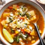 Mexican Vegetable Soup in a bowl garnished with lime juice and cotija cheese.