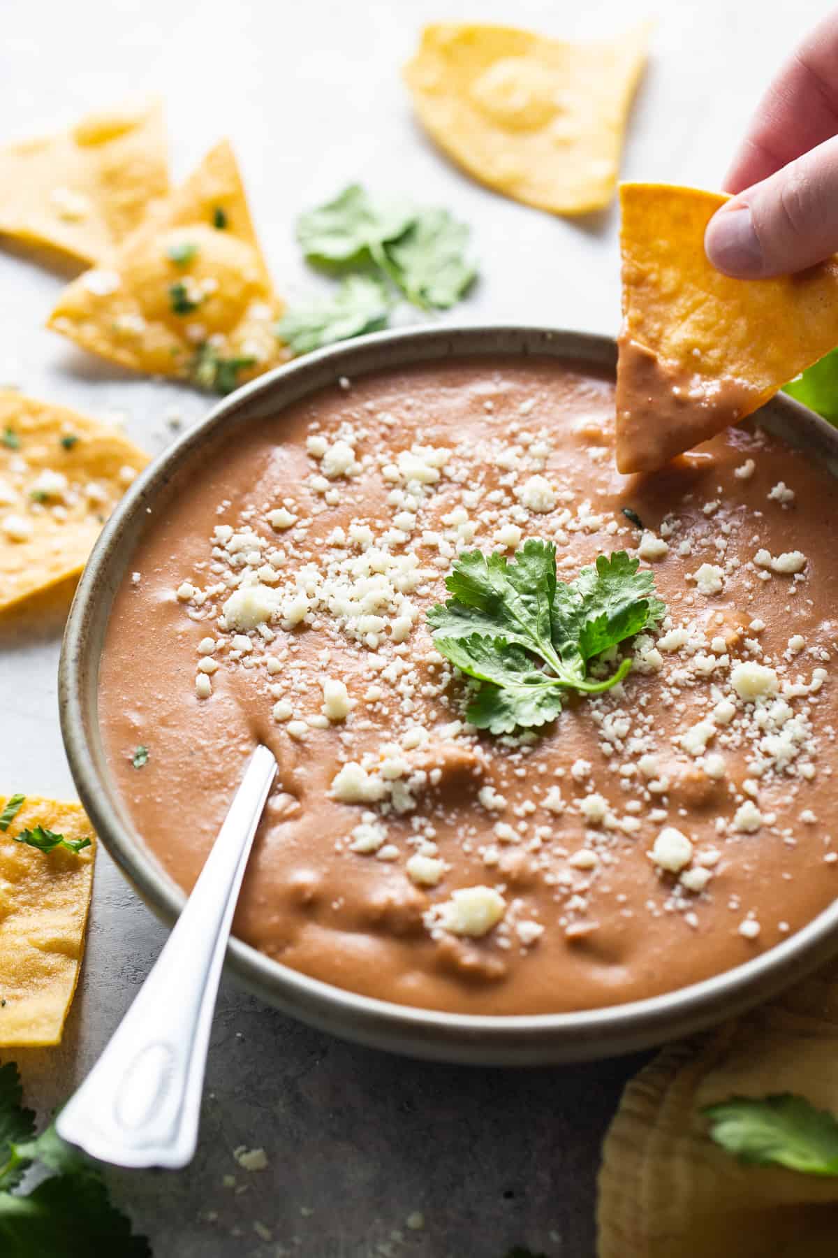 Frijoles puercos garnished with cotija cheese and cilantro in a bowl.