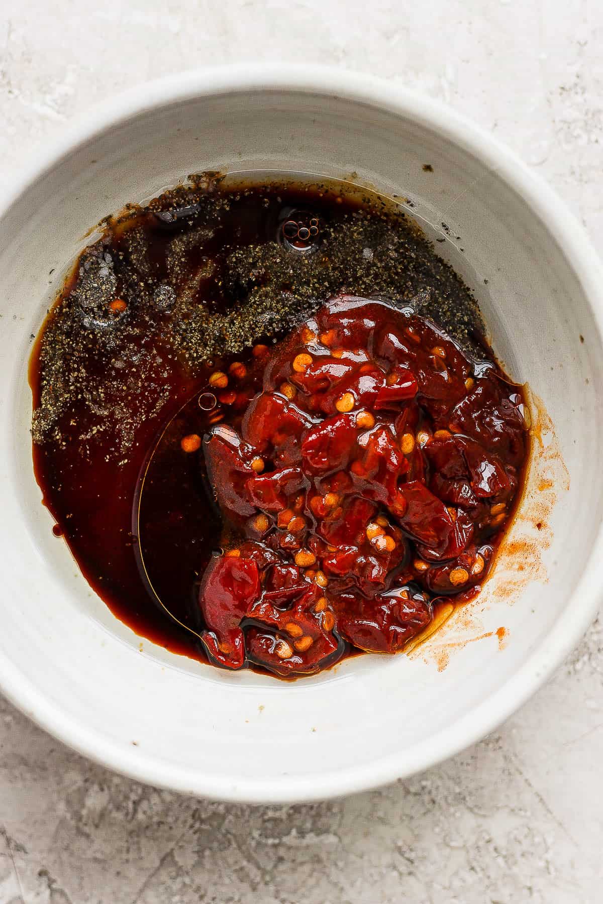 A small bowl with chopped chipotle peppers in adobo sauce, honey, and soy sauce.