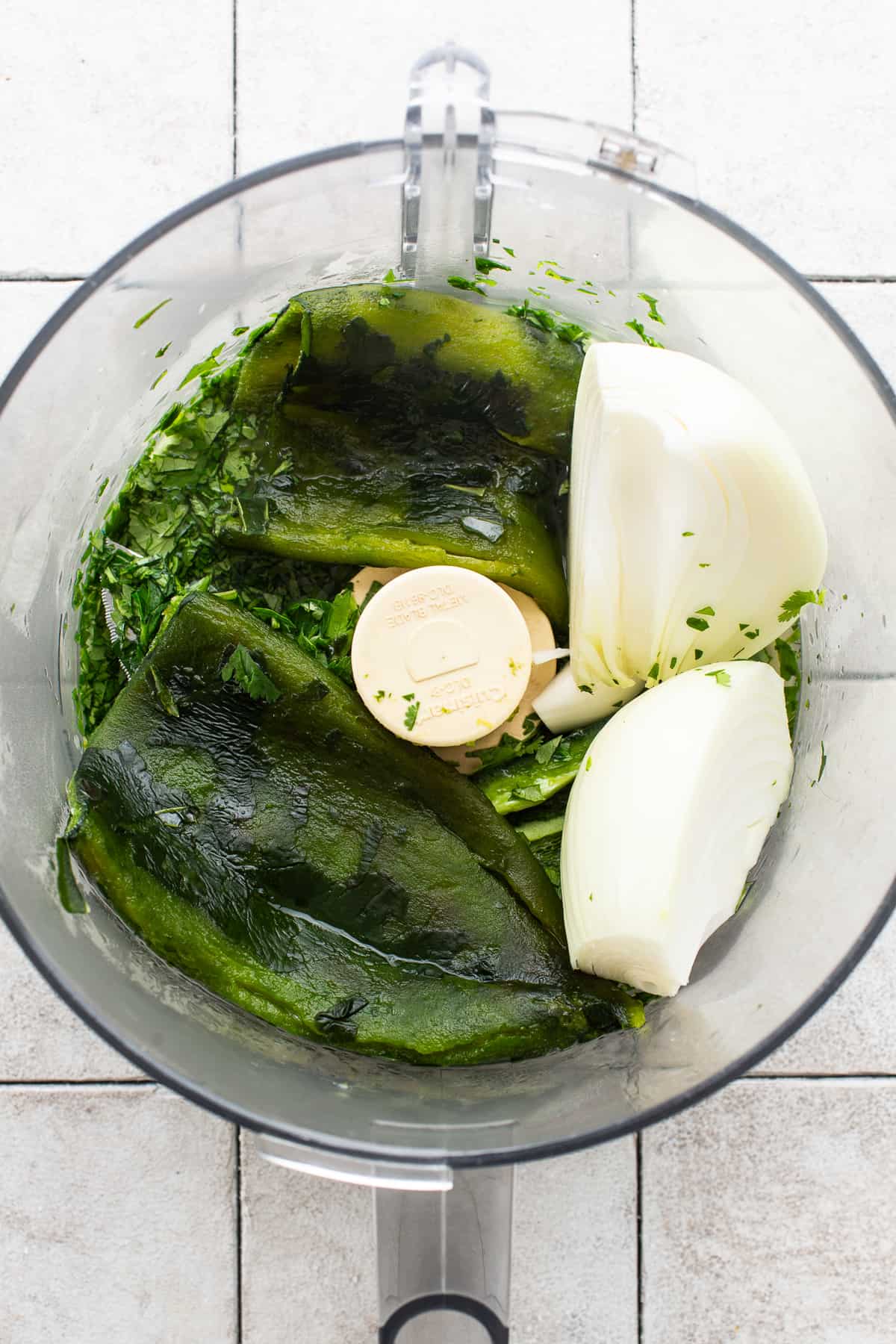 Roasted poblanos, cilantro, parsley, and onion in a food processor.