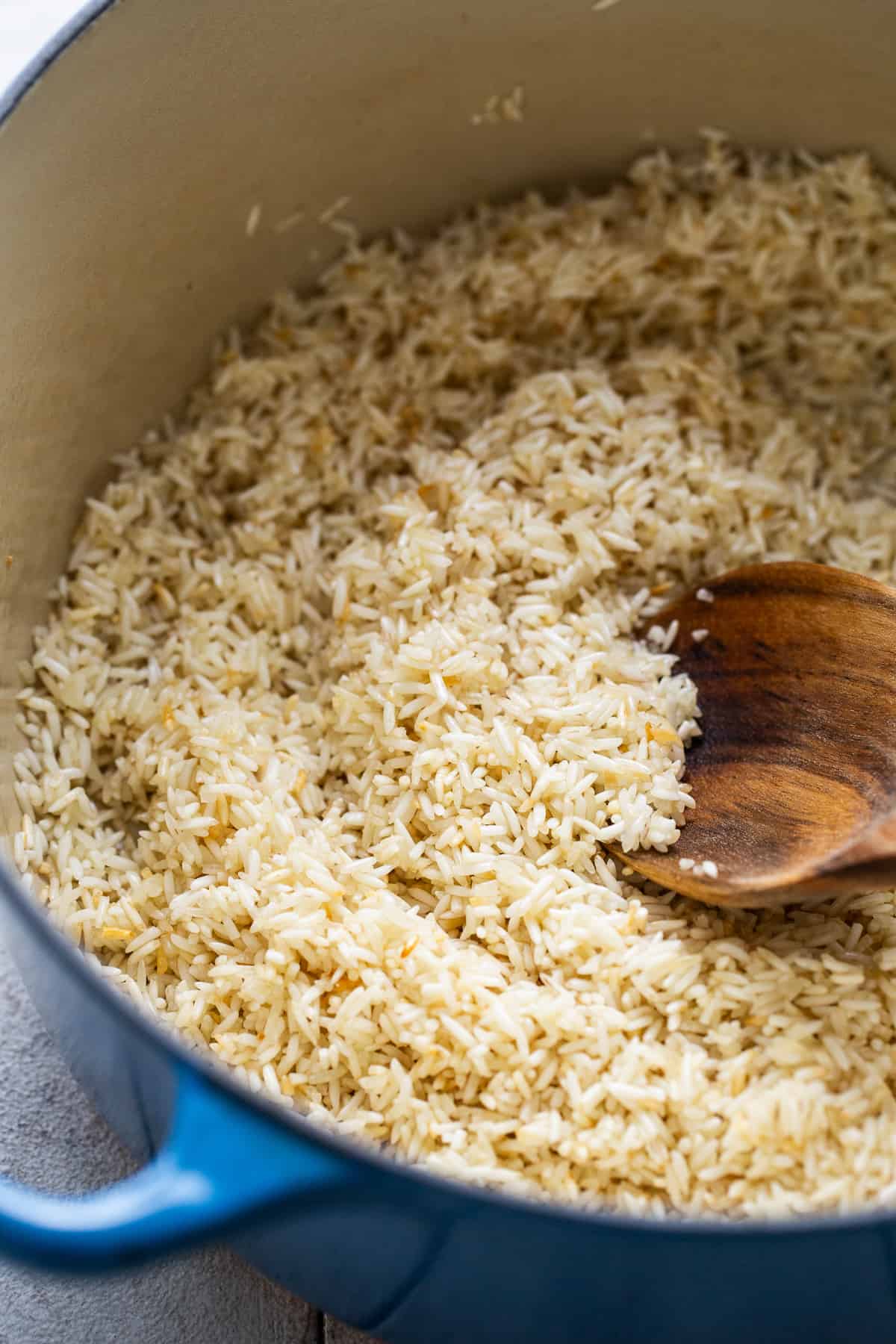 Long grain white rice being toasted in a pot to make arroz verde.