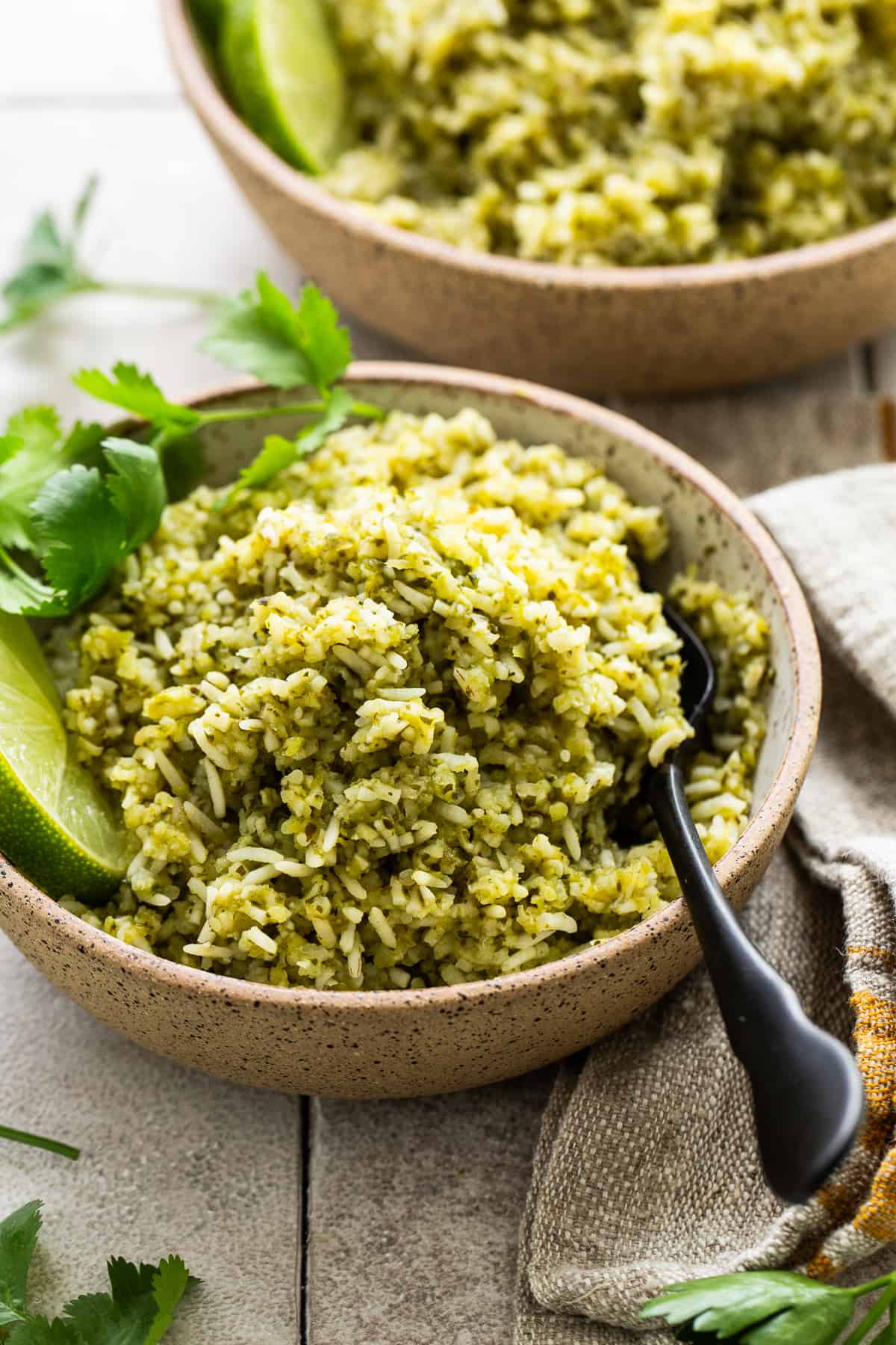 Arroz verde in a bowl garnished with some cilantro leaves.