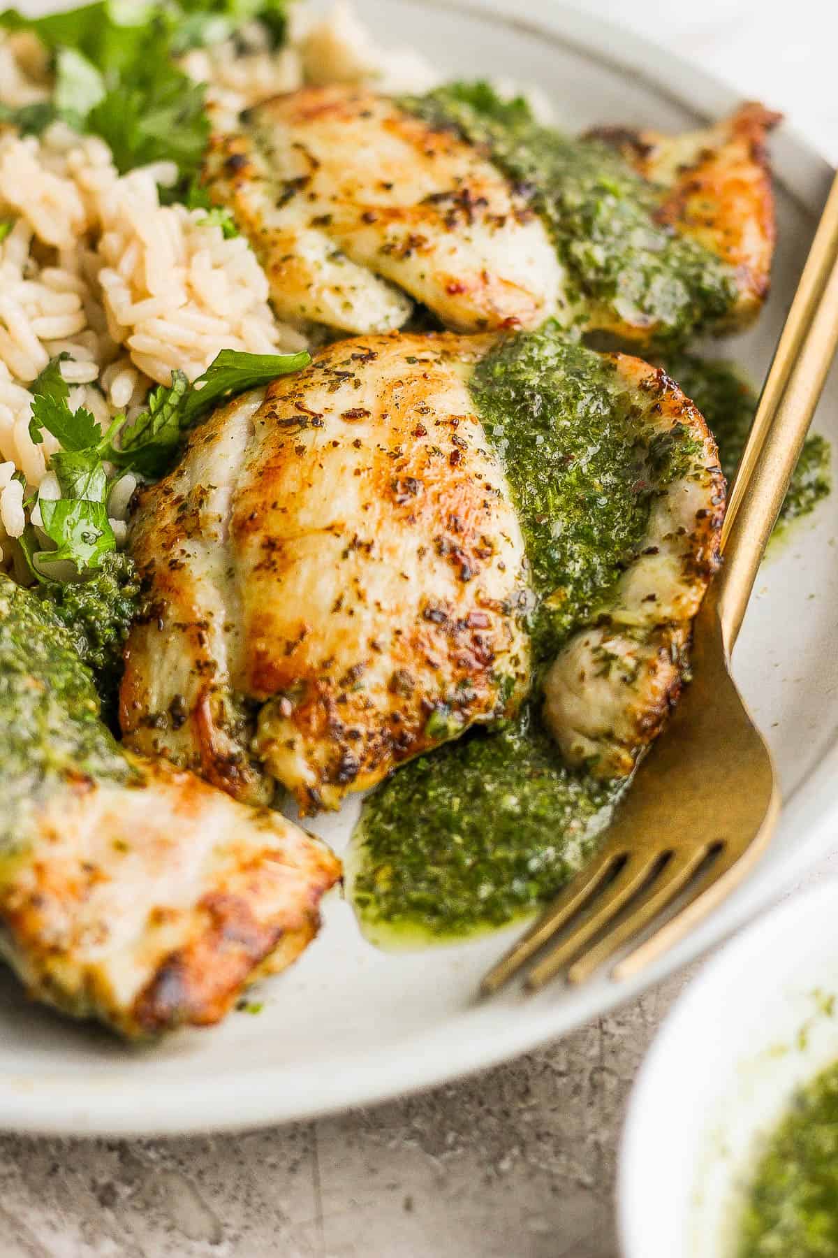 Pan seared chimichurri chicken drizzled with chimichurri sauce and served next to cilantro lime rice.