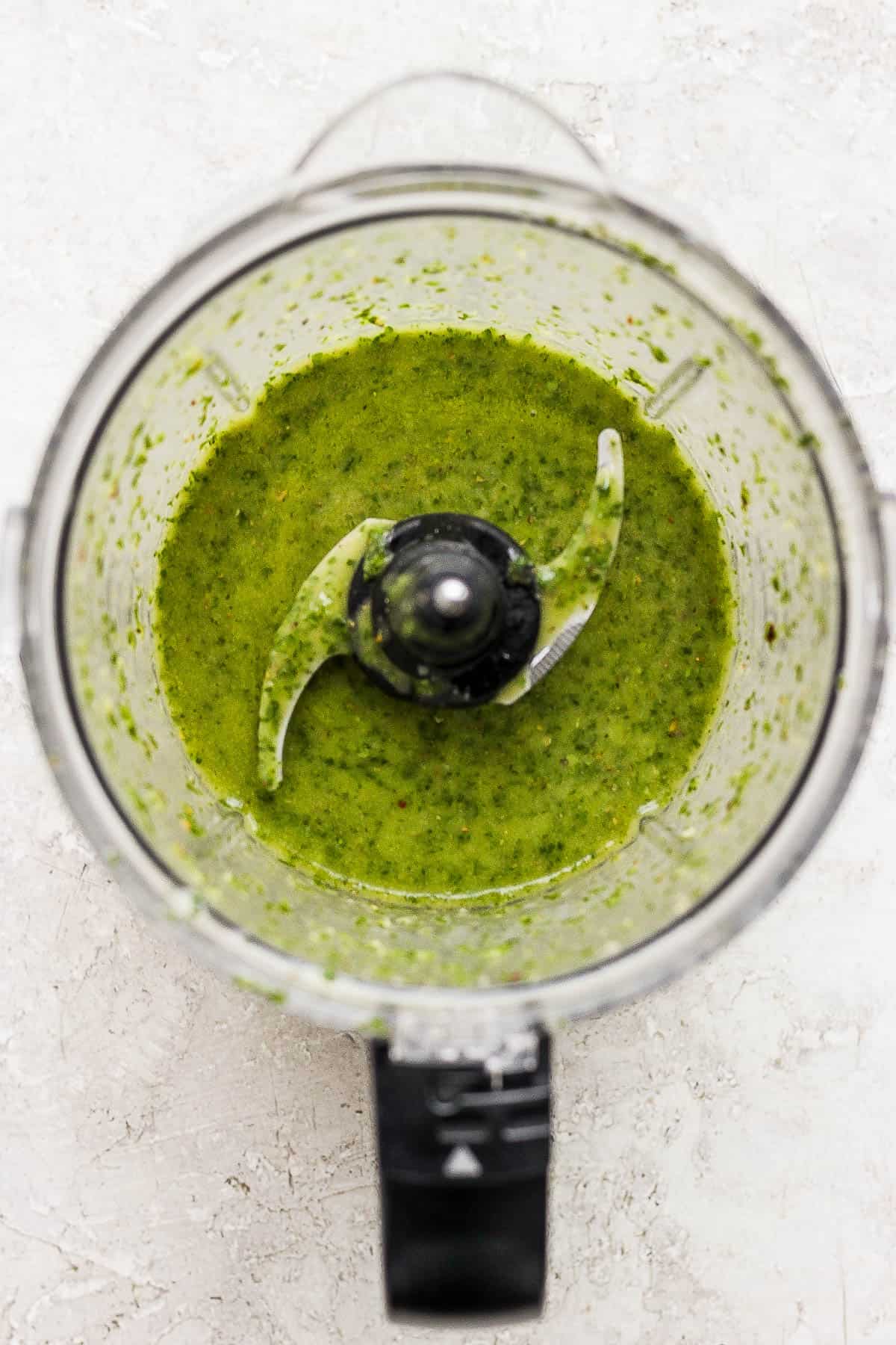 Blended chimichurri sauce in a food processor.