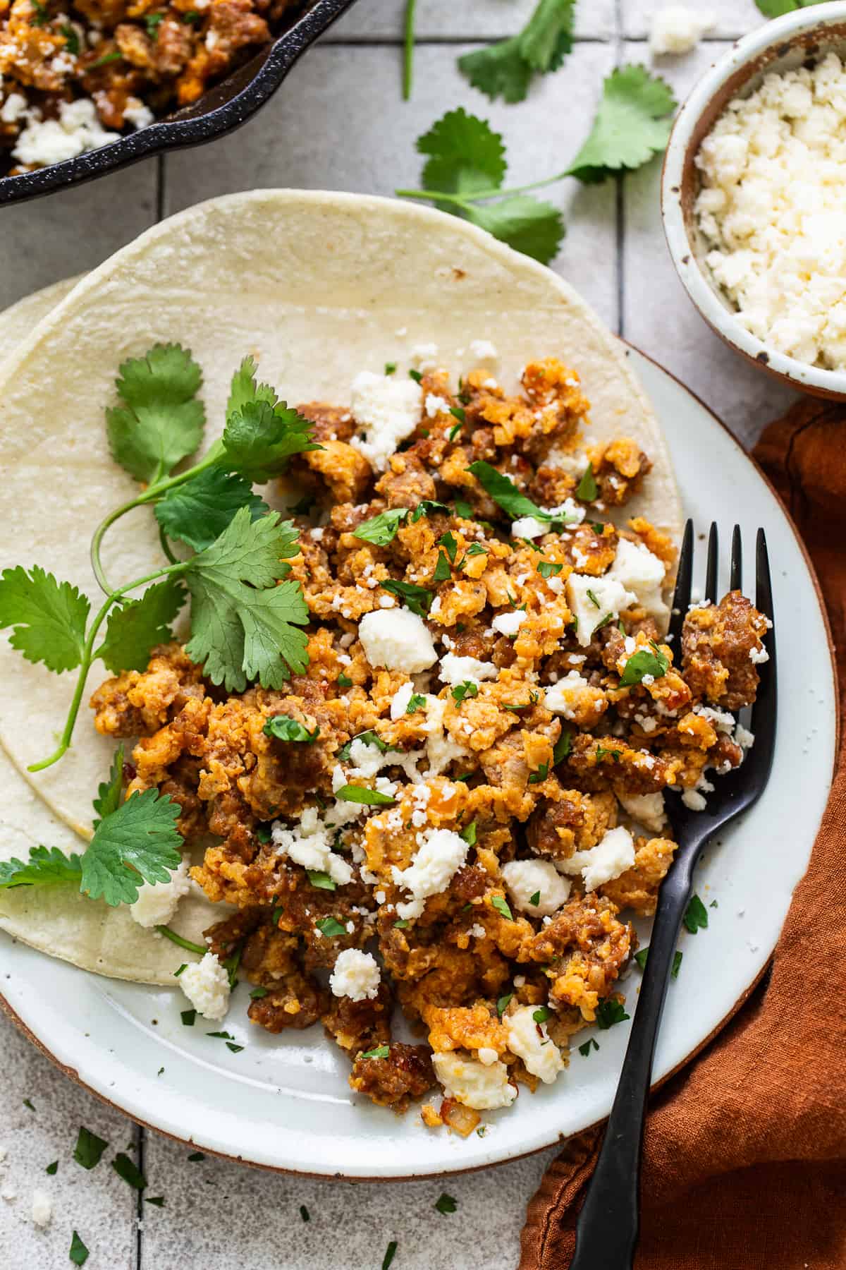 Chorizo and eggs on corn tortillas served with crumbled queso fresco and cilantro.