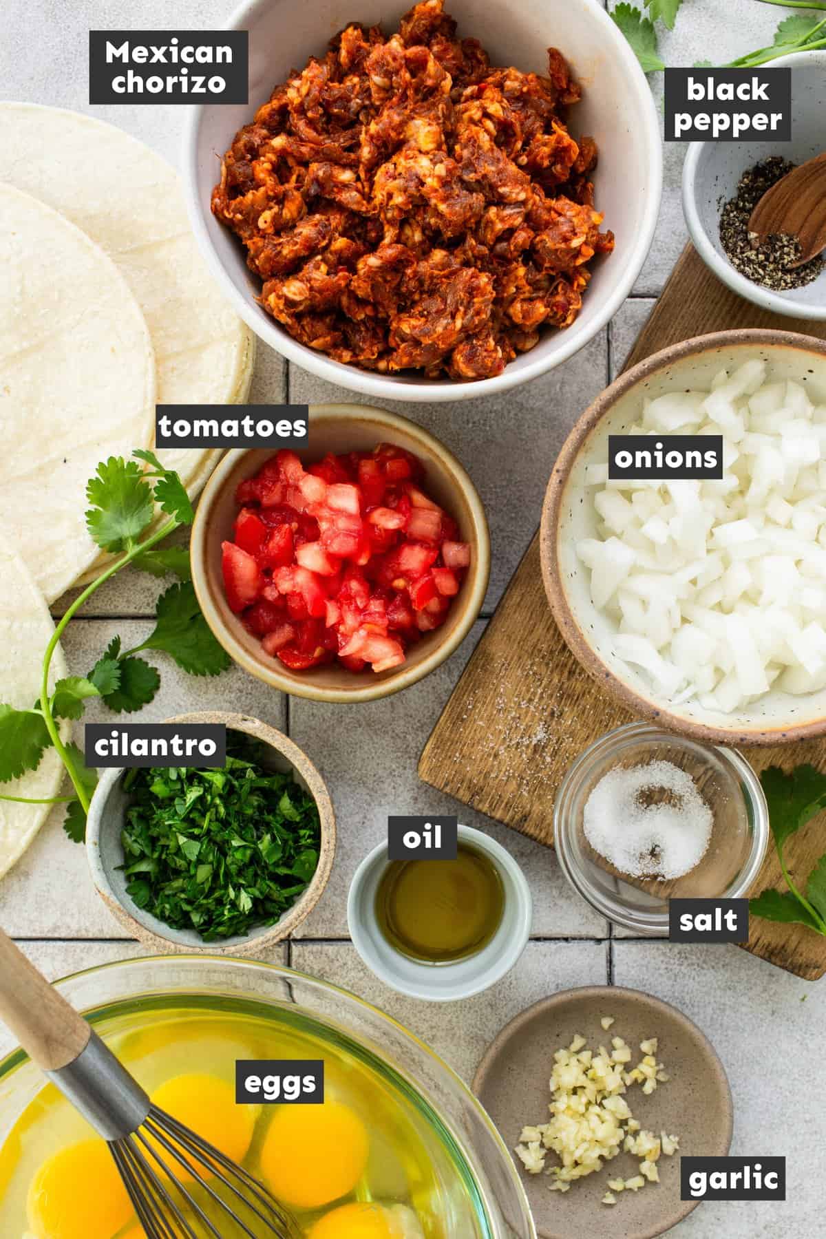 Ingredients in chorizo and eggs on a table.