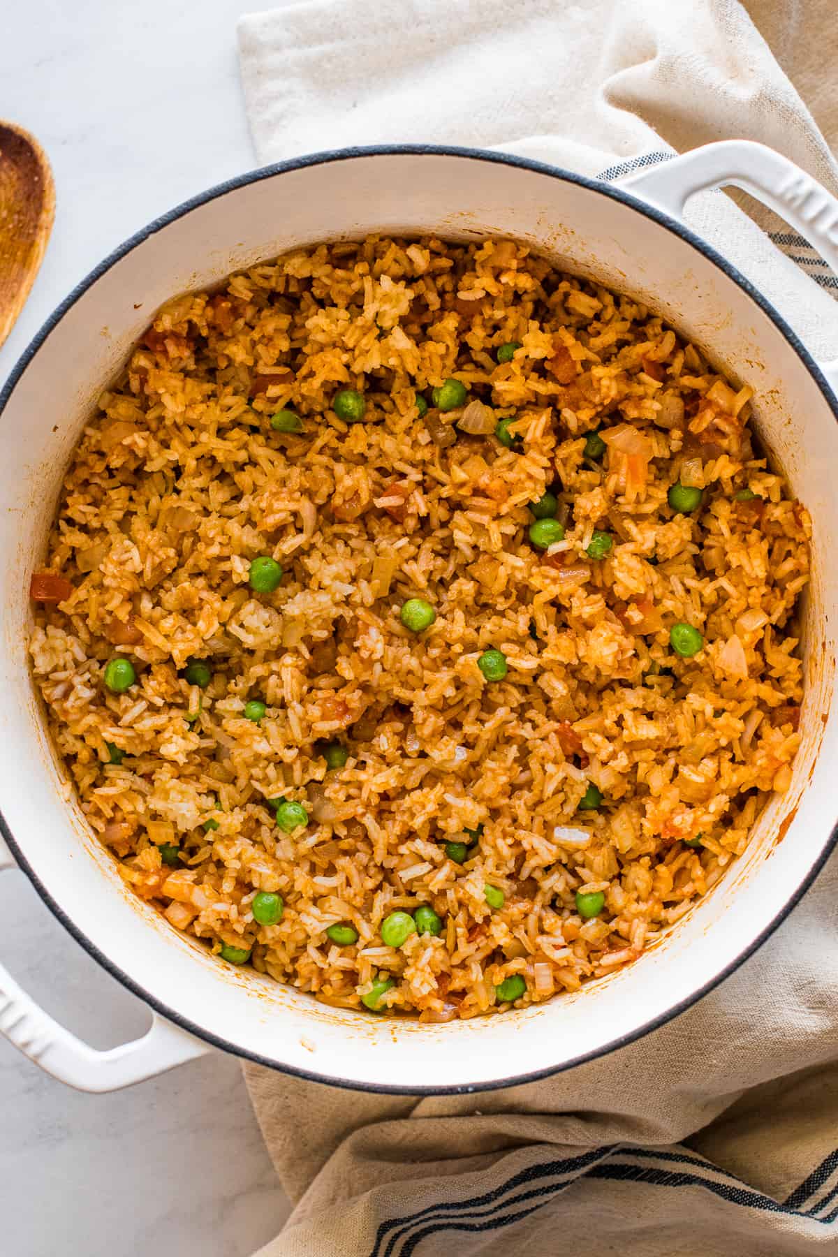 Authentic Mexican rice (arroz rojo) in a pot with green peas throughout.