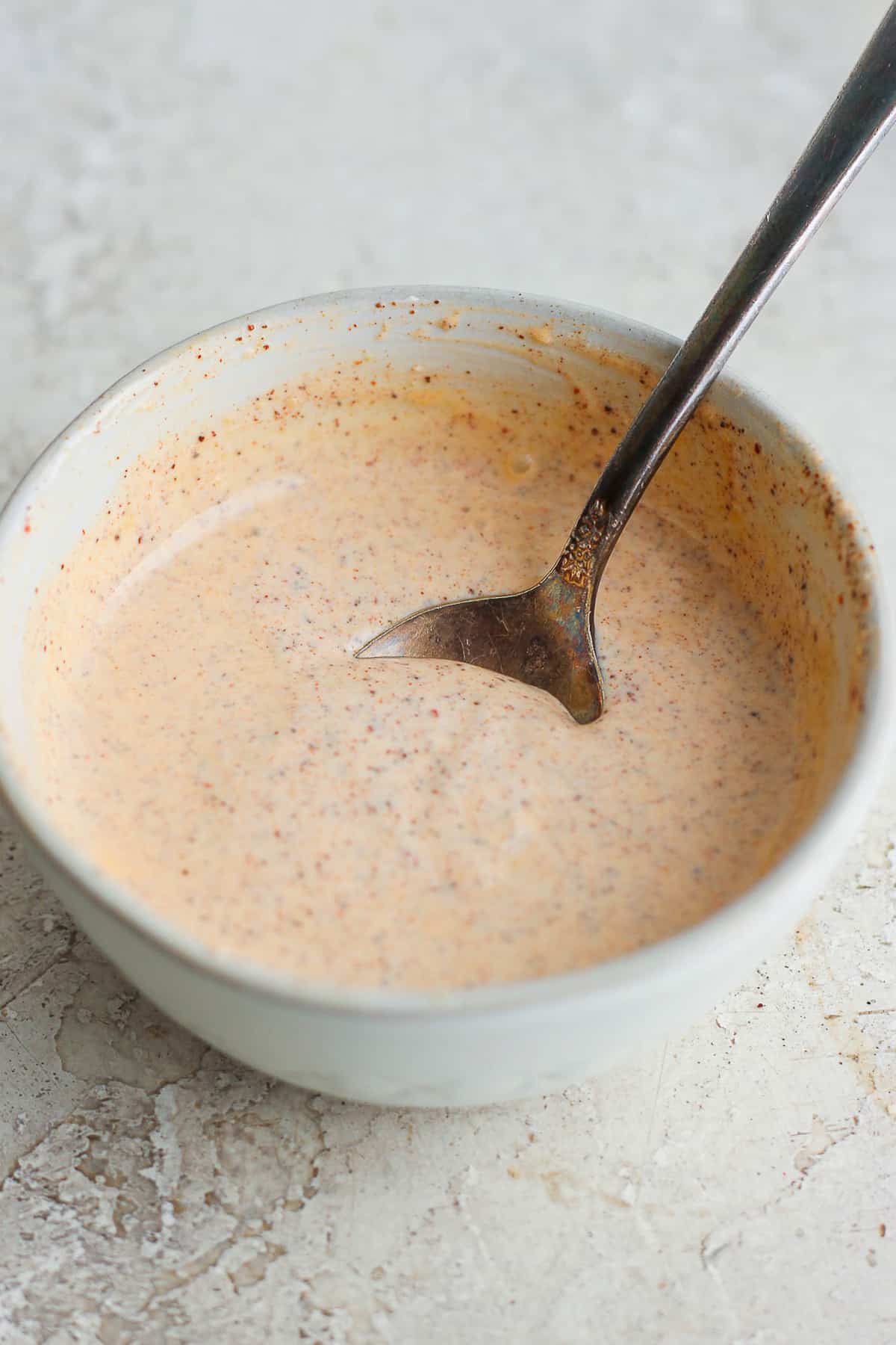 A simple chili lime sauce in a bowl with a spoon inside.