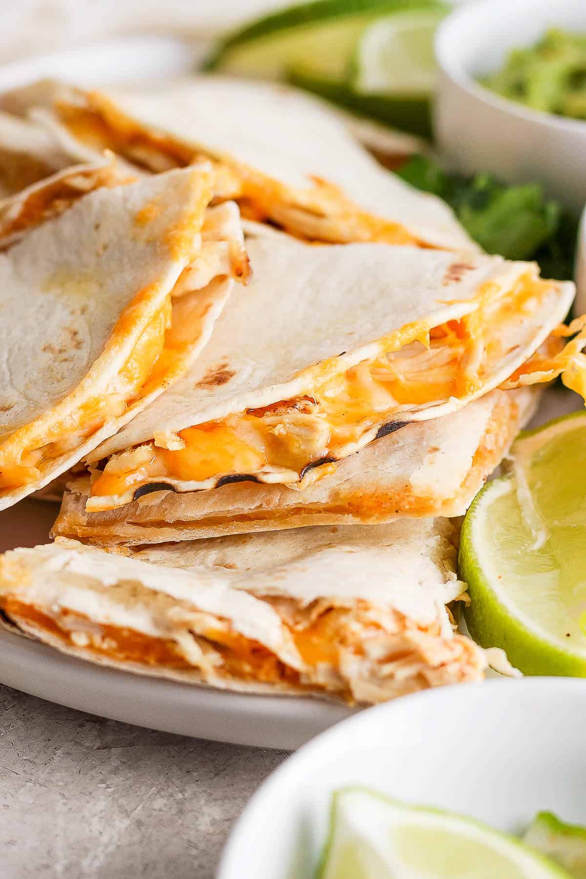 Cheesy air fryer chicken quesadillas cut into triangles and served on a plate.