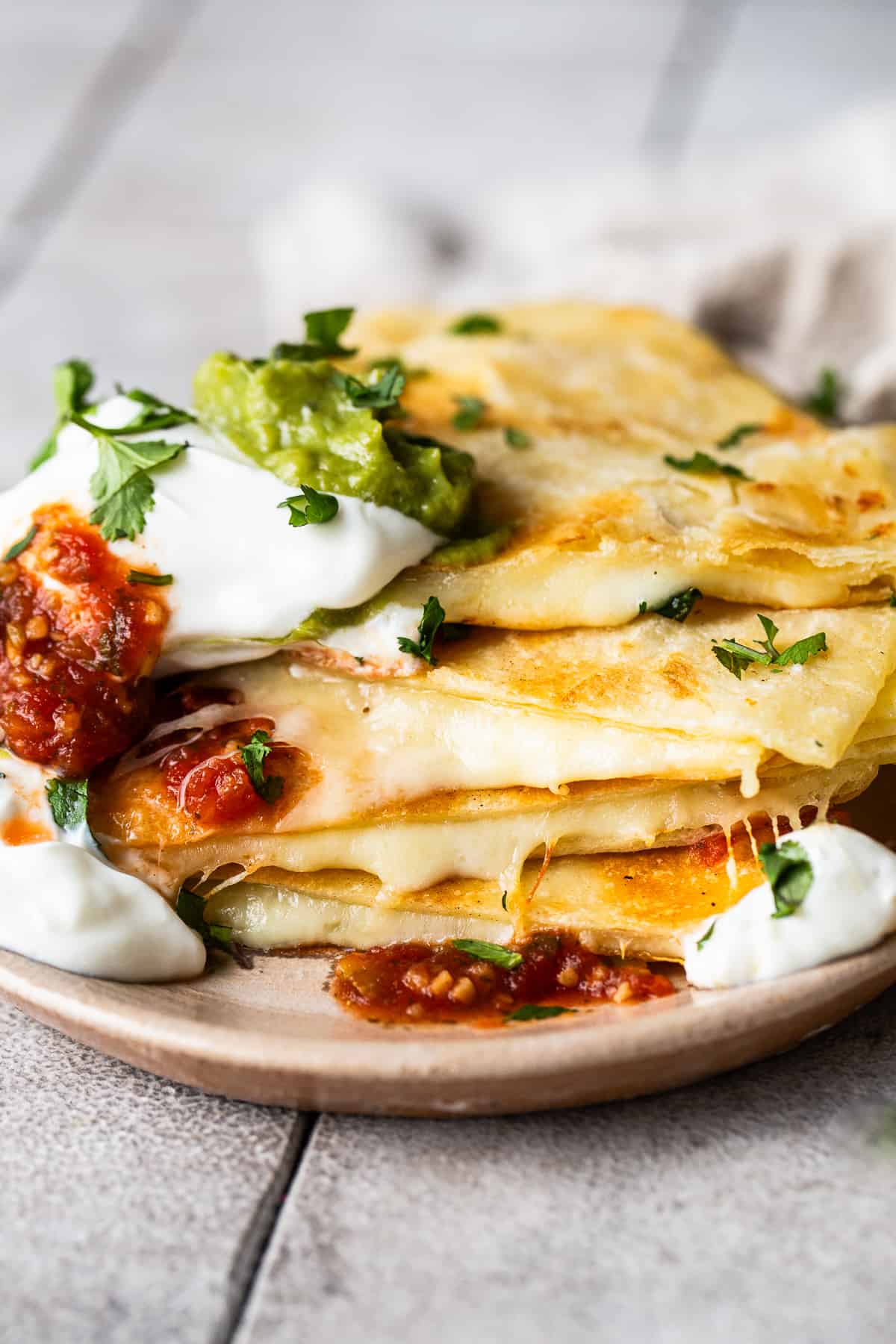Cheese quesadillas on a plate stacked on top of each other.