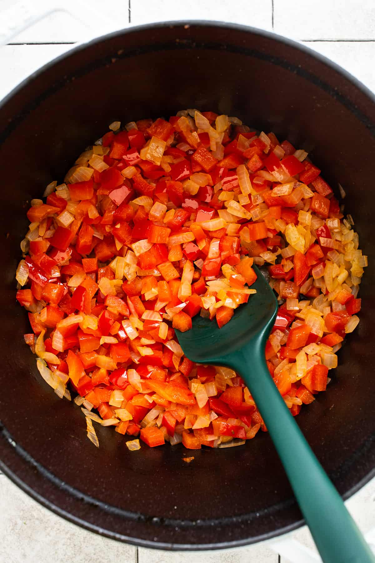 Bell peppers and onions cooked in a pot.
