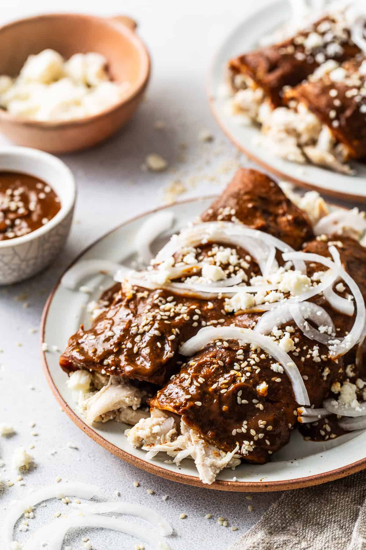 Chicken Enmoladas on a plate with shfredded chicken coming out.