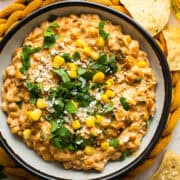 Street corn dip in a bowl with tortilla chips.