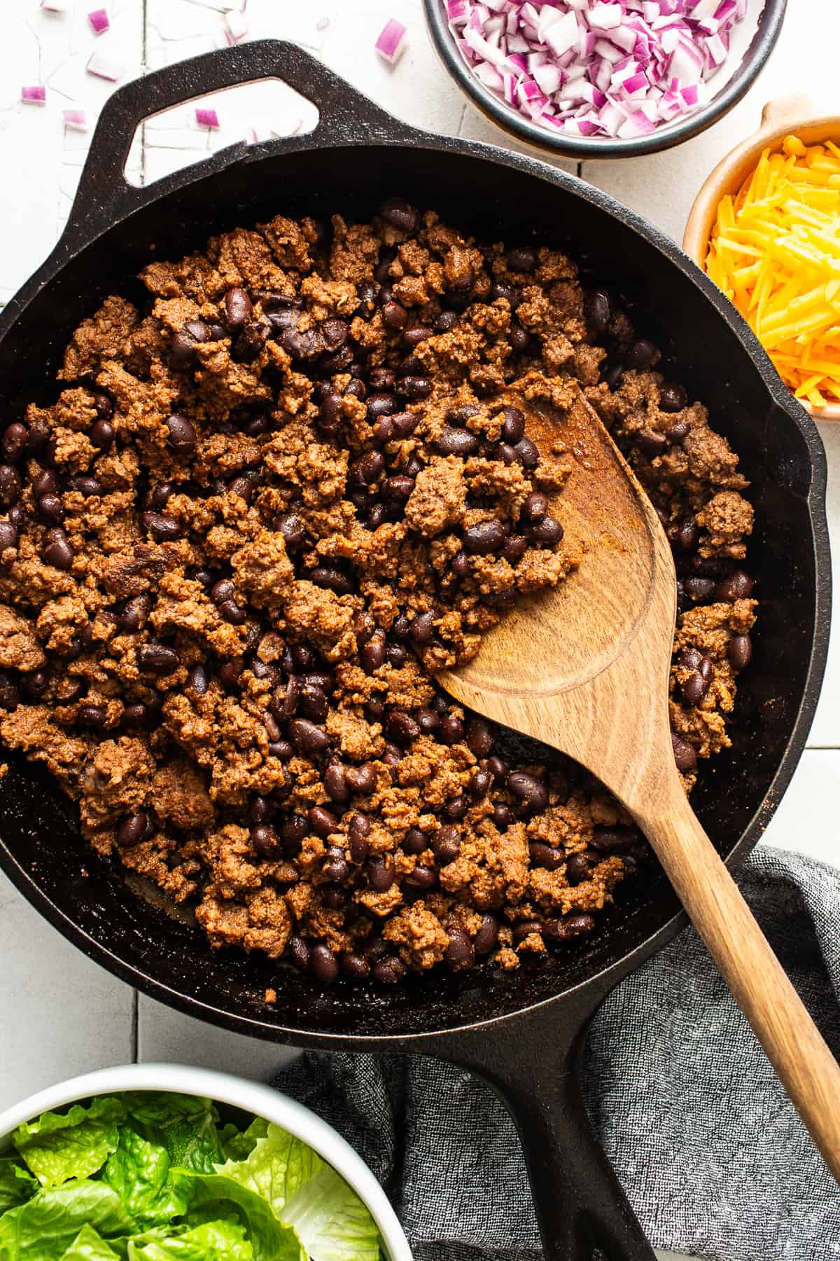 Ground beef and black beans cooked in a large cast iron skillet.