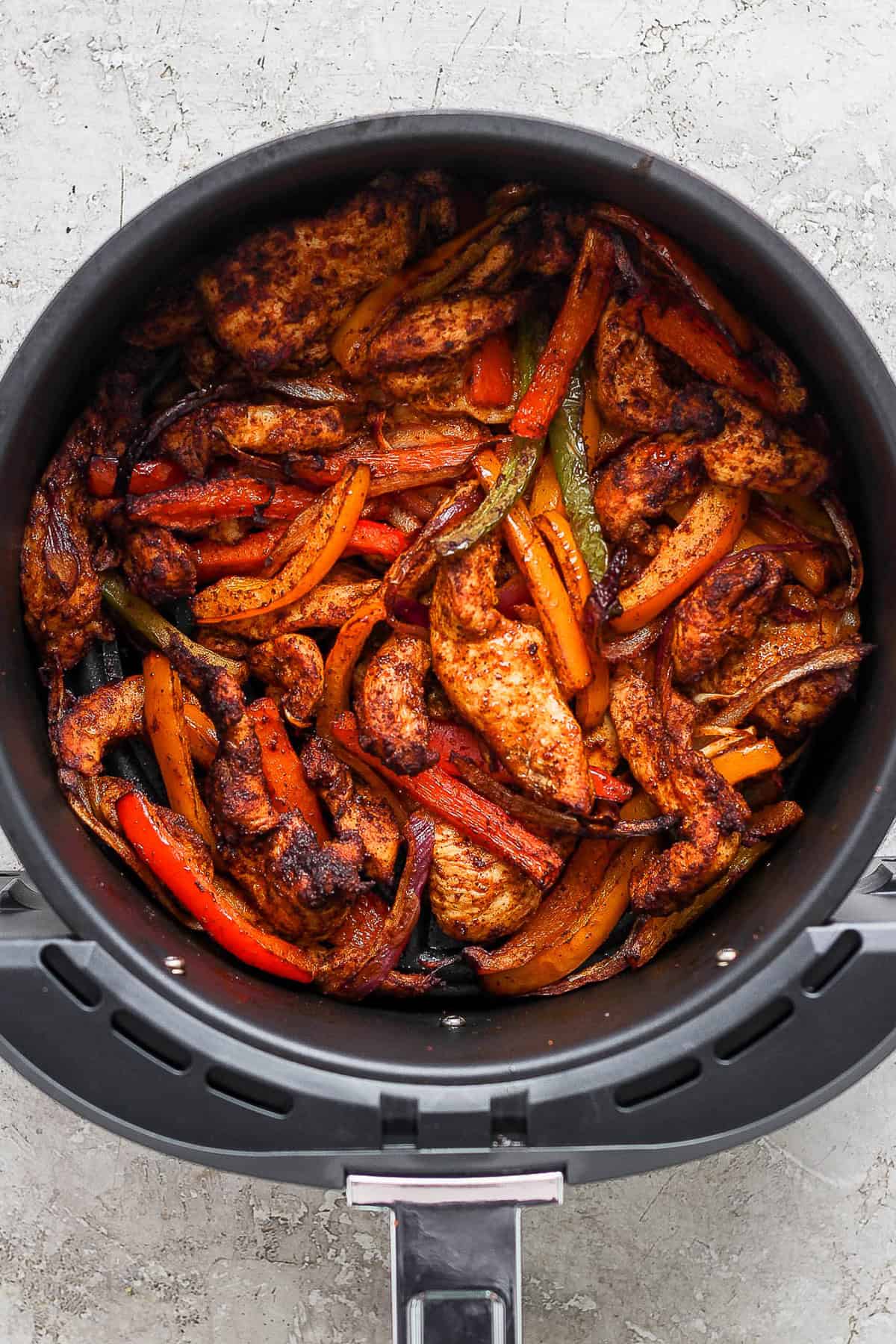 Air Fryer Chicken Fajitas in an air fryer basket ready to be served.