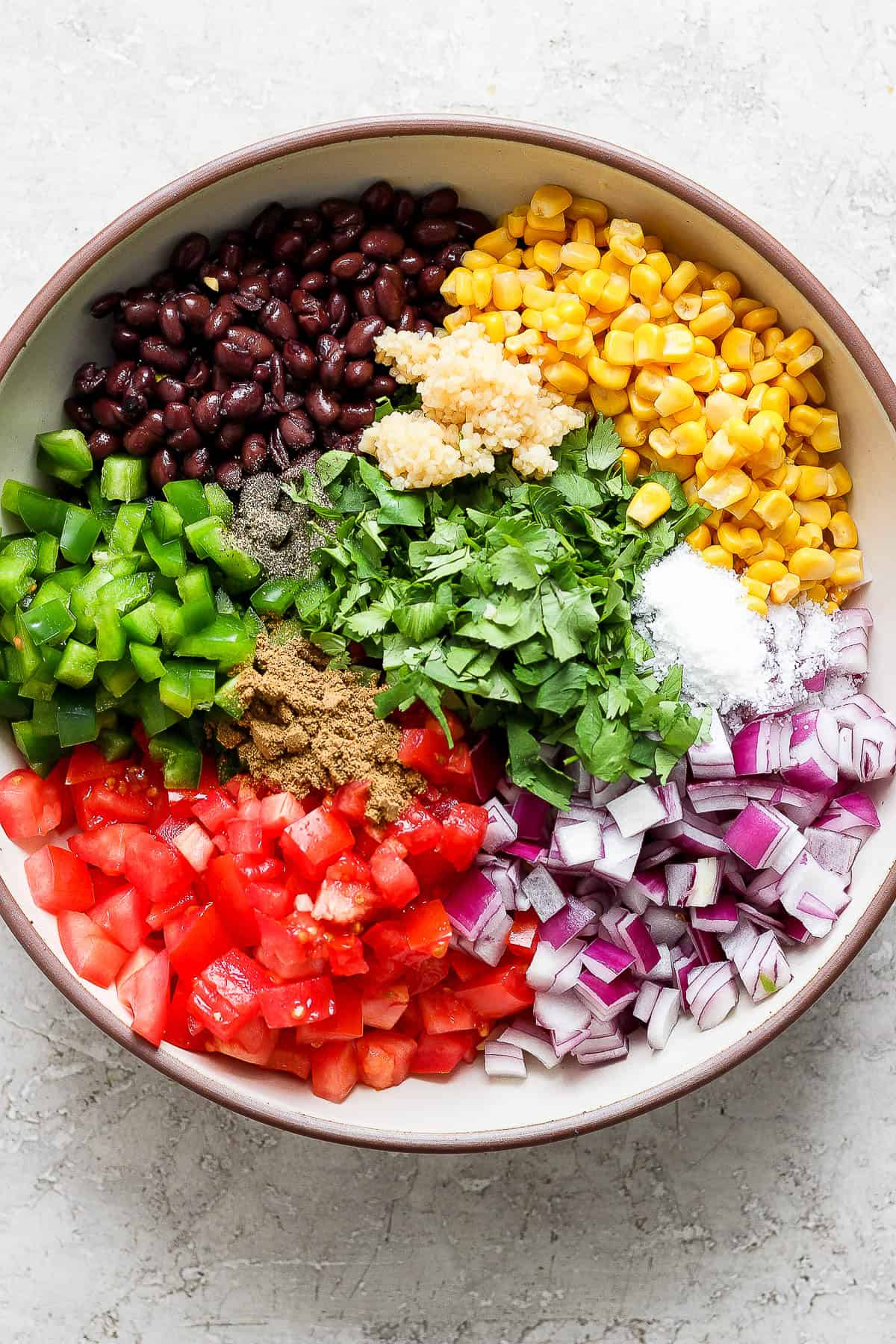 A bowl of ingredients for black bean and corn salsa.