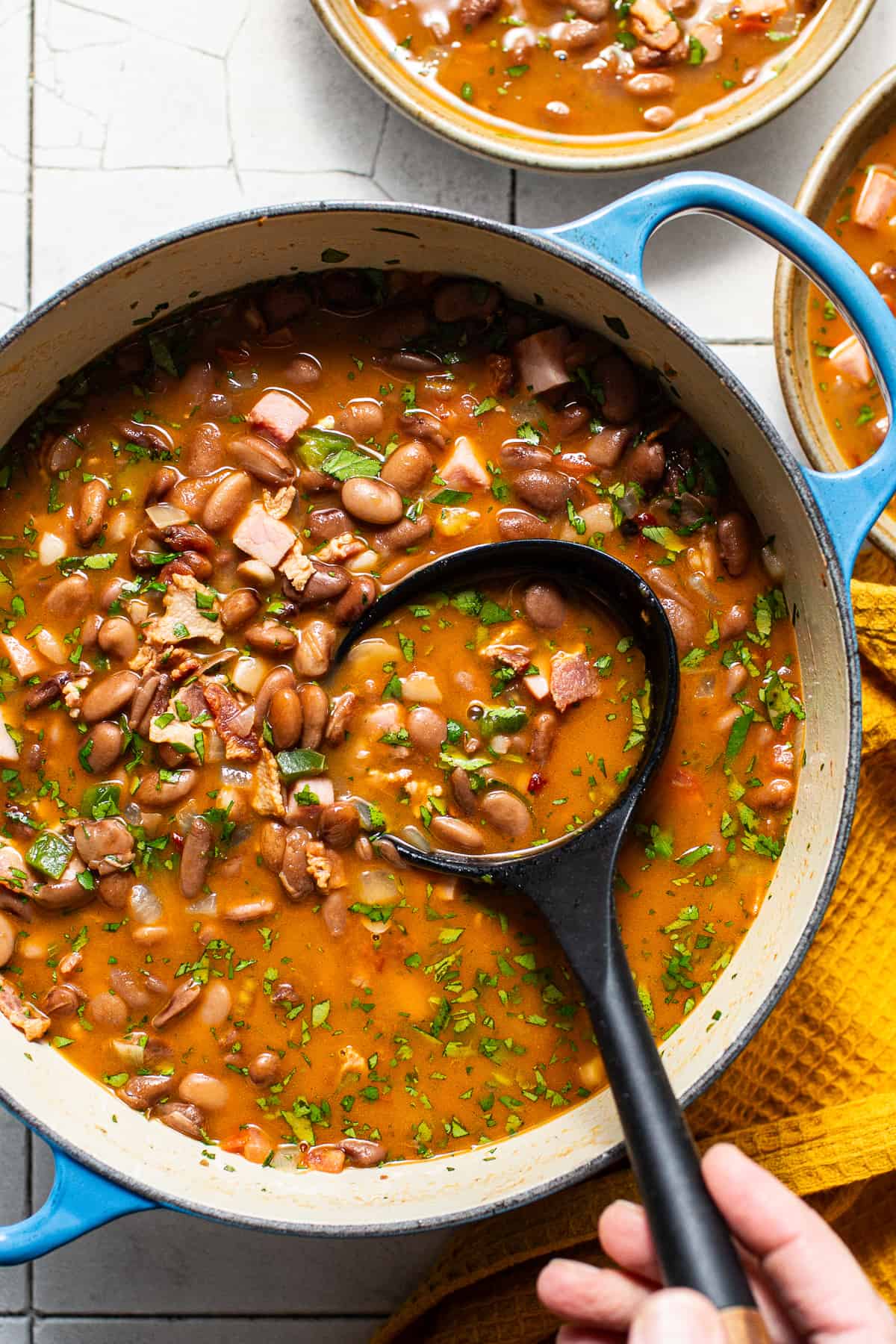 Charro beans in a pot with a ladle about to be served.