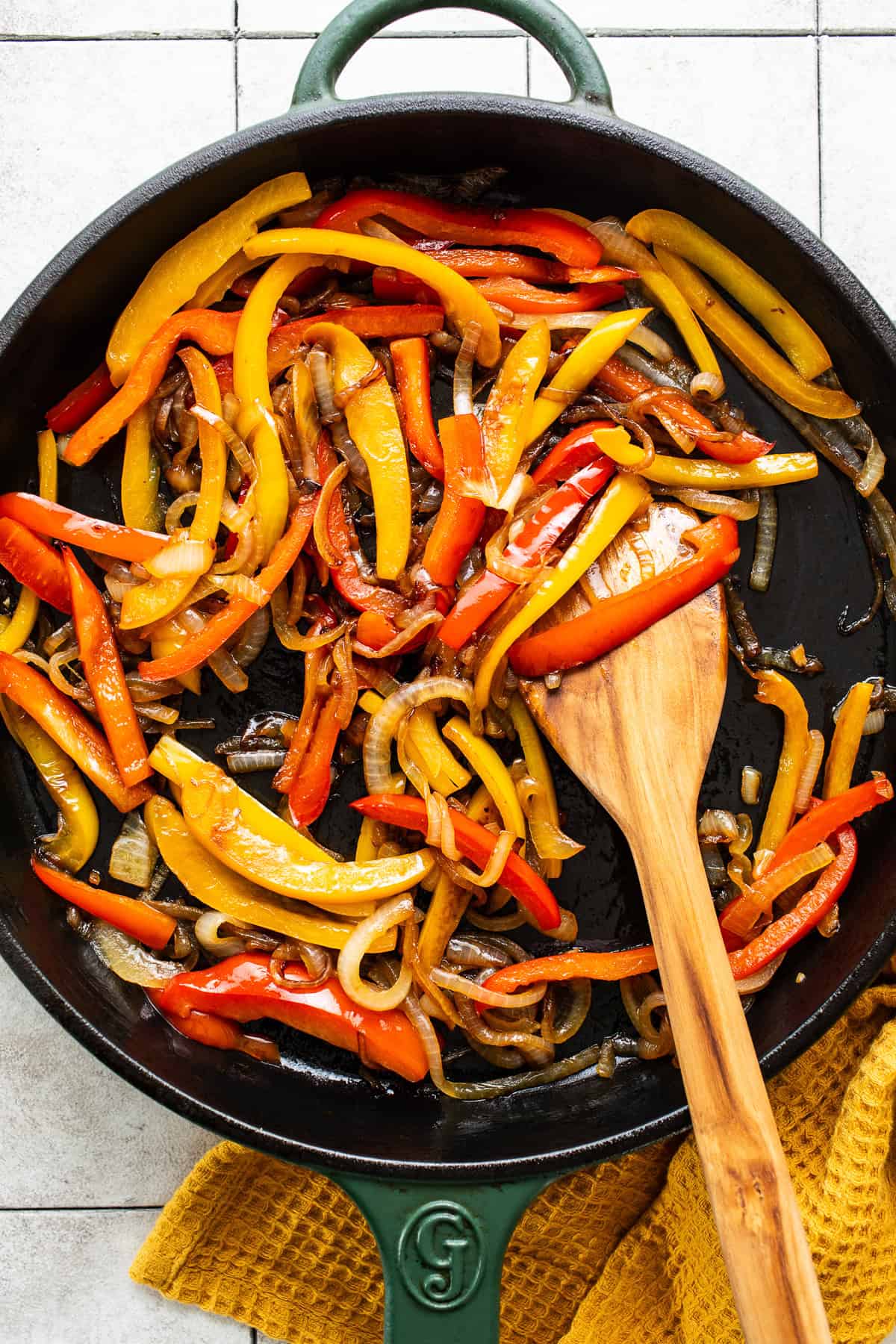 Bell peppers and onions sauteed in a large skillet.