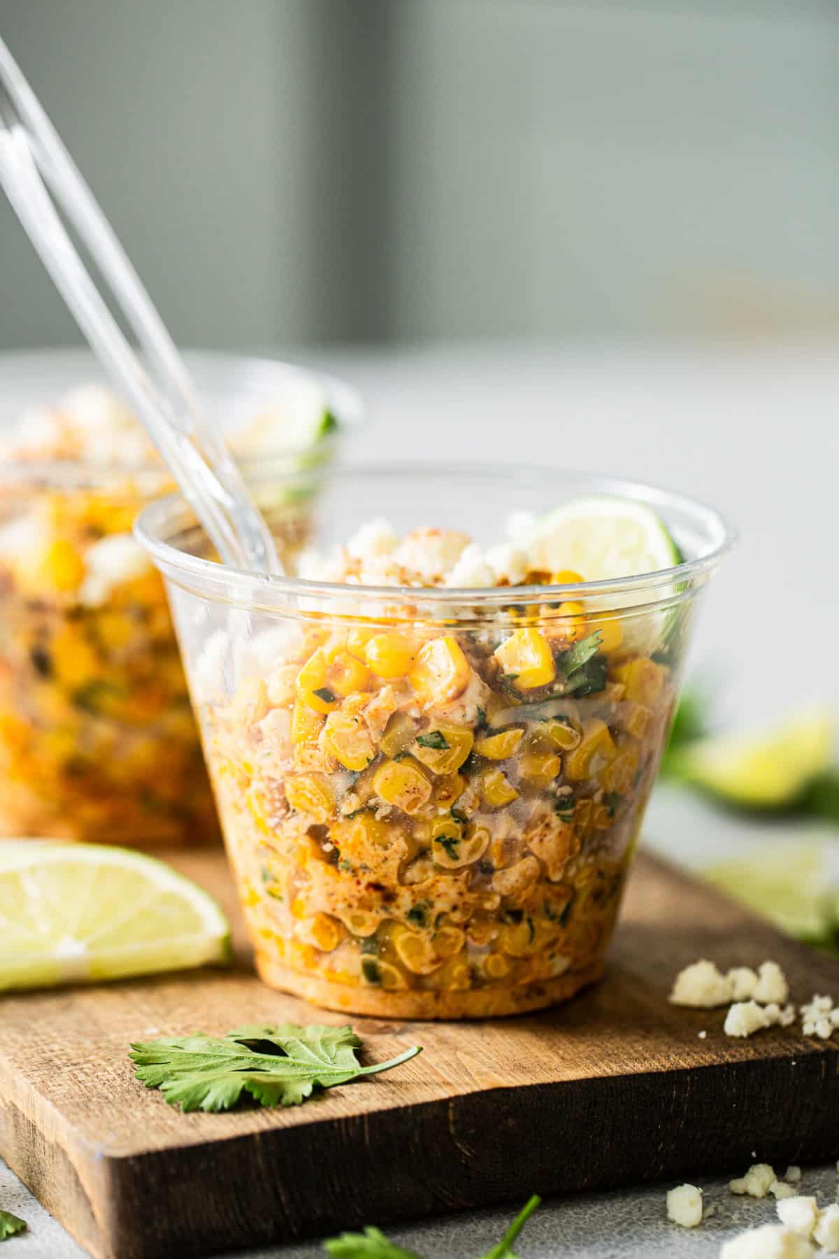 Esquites served into a cup with limes