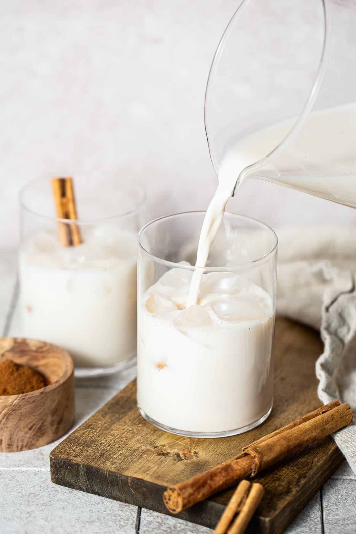Horchata being poured over ice in glasses
